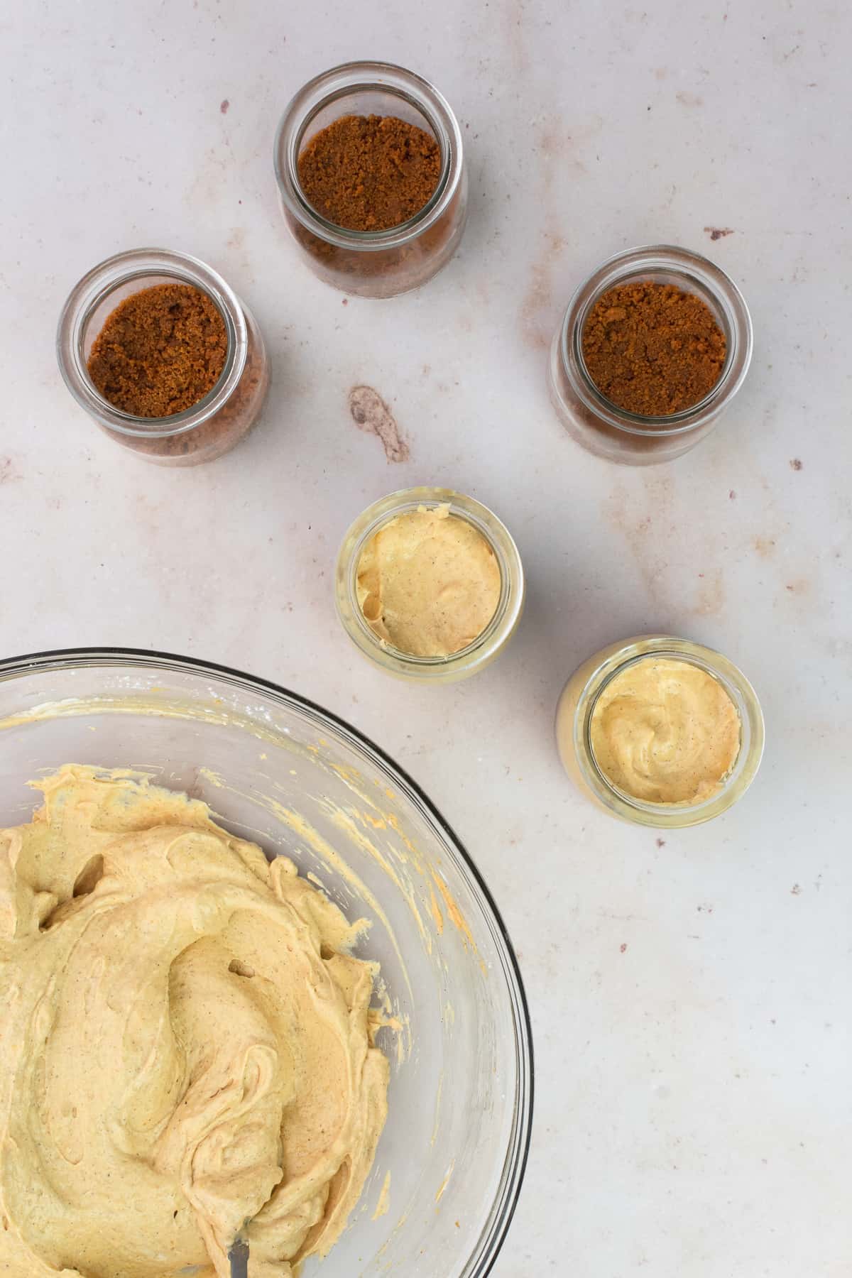 Cheesecake filling is added to little jars