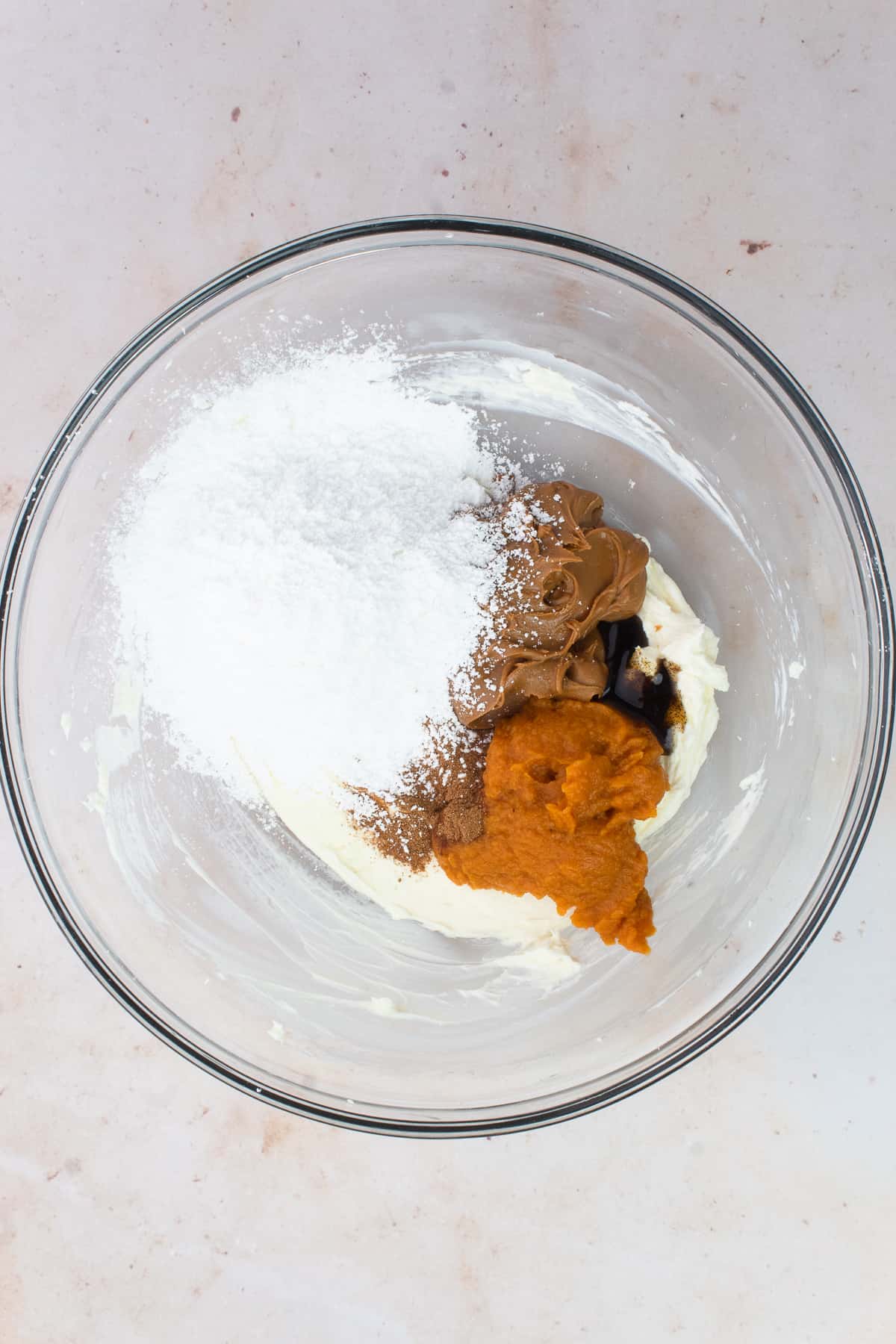 A bowl of cream cheese, pumpkin puree, powdered sugar, cookie butter and vanilla