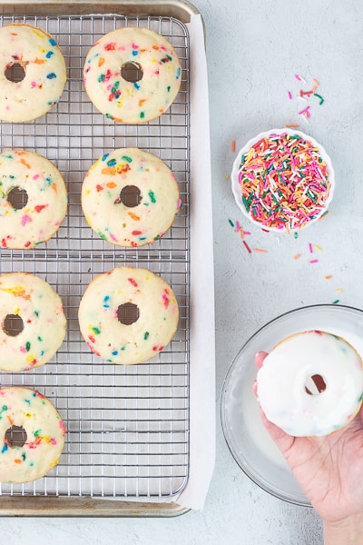 dipping a donut in glaze