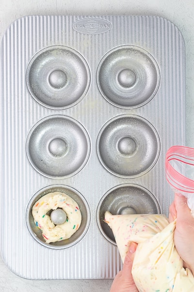 piping batter into donut pan