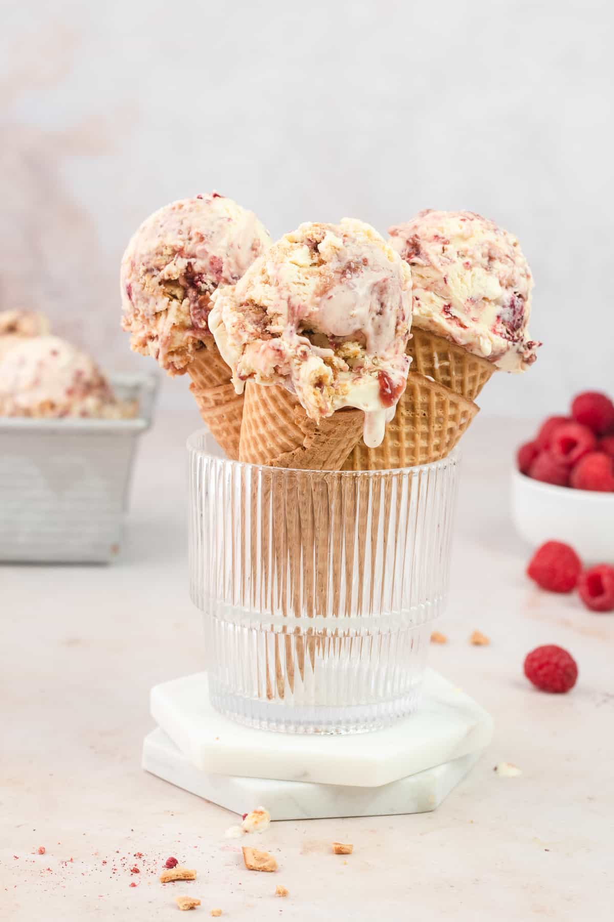 Three ice cream cones with three scoops of ice cream in a glass cup