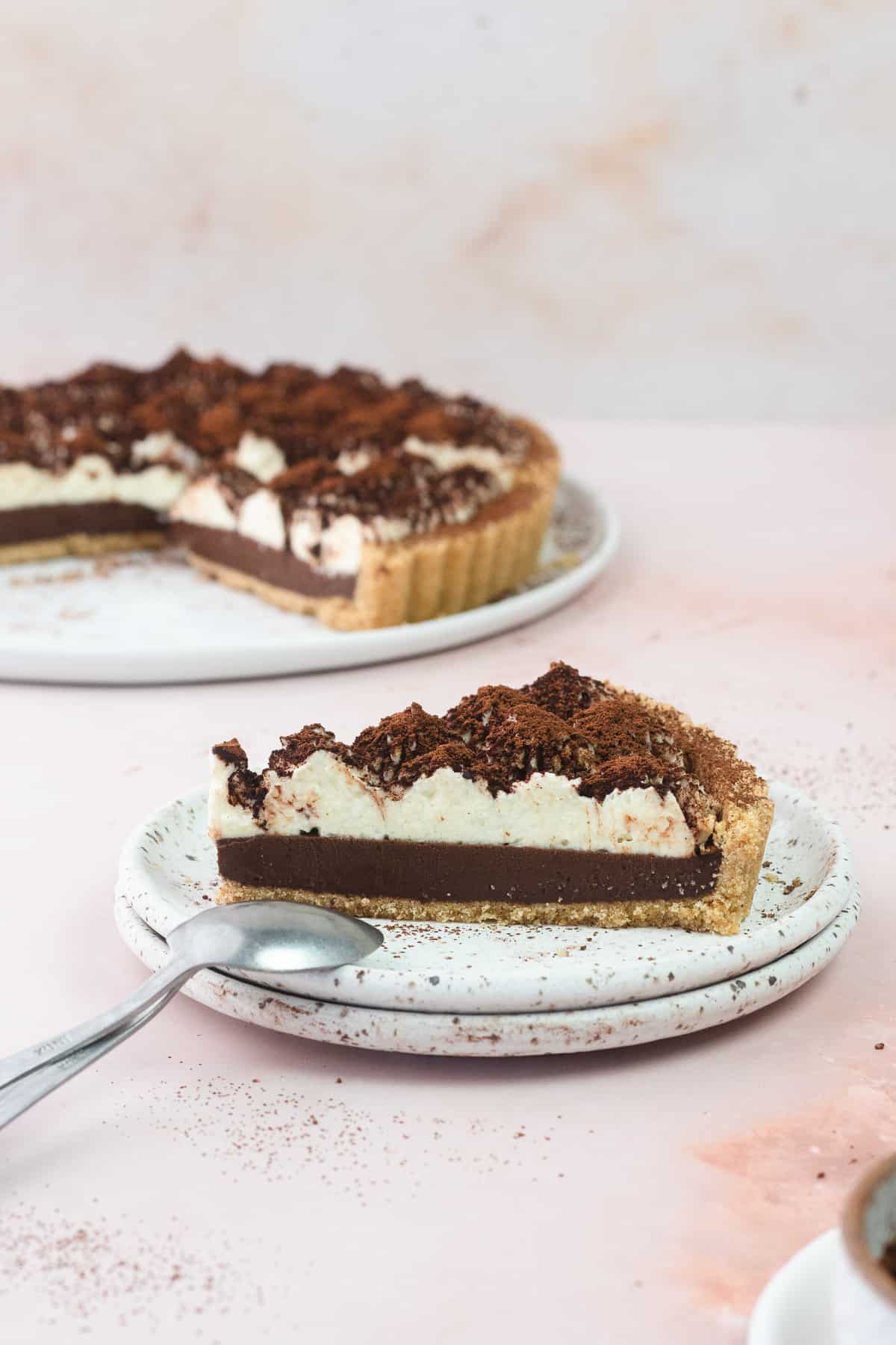 A cross section of a slice of tiramisu tart on a plate