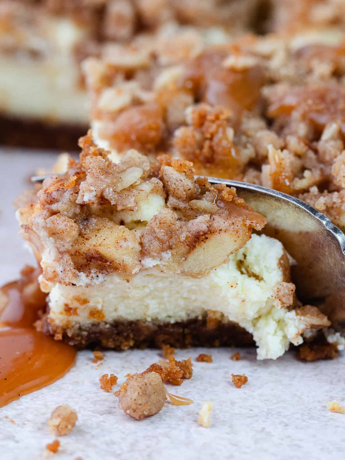 Close up of a piece of apple crisp cheesecake bar