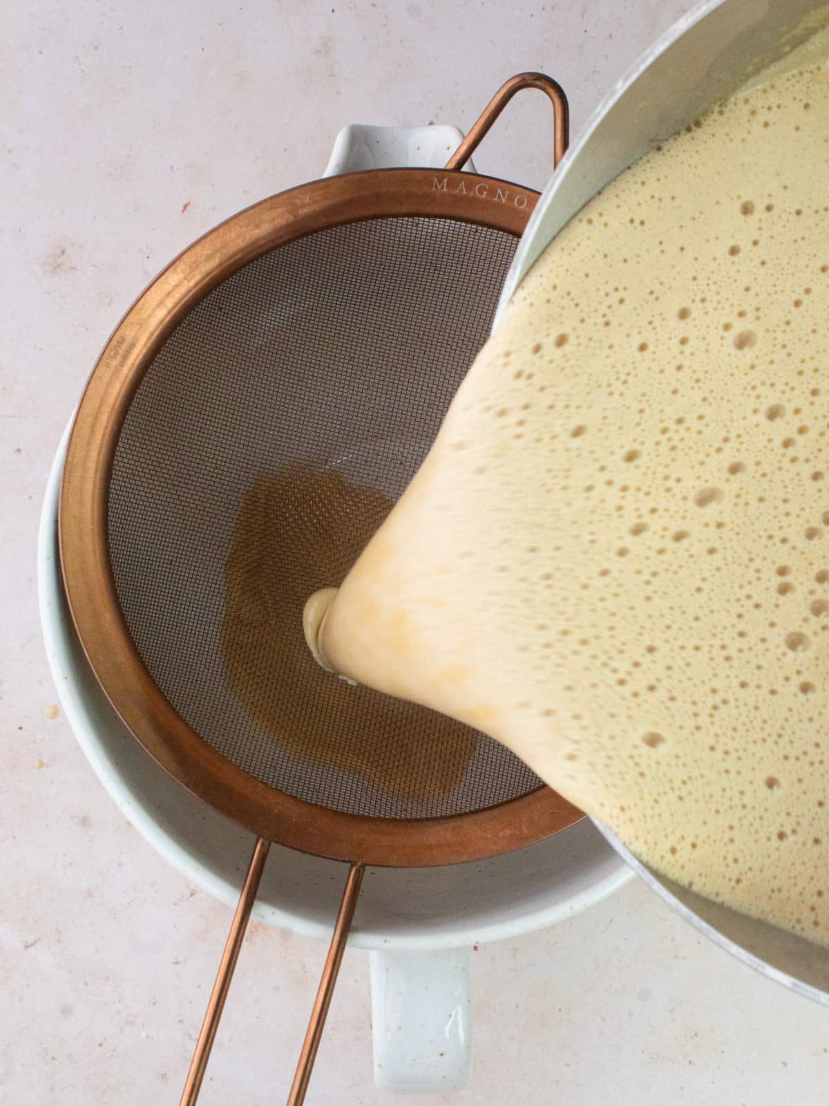 straining custard into clean bowl