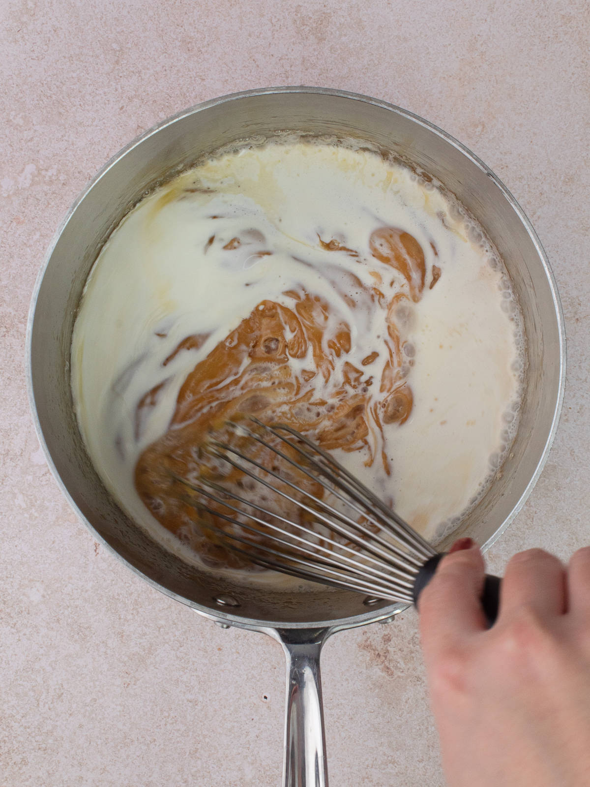 Heavy cream added to caramel