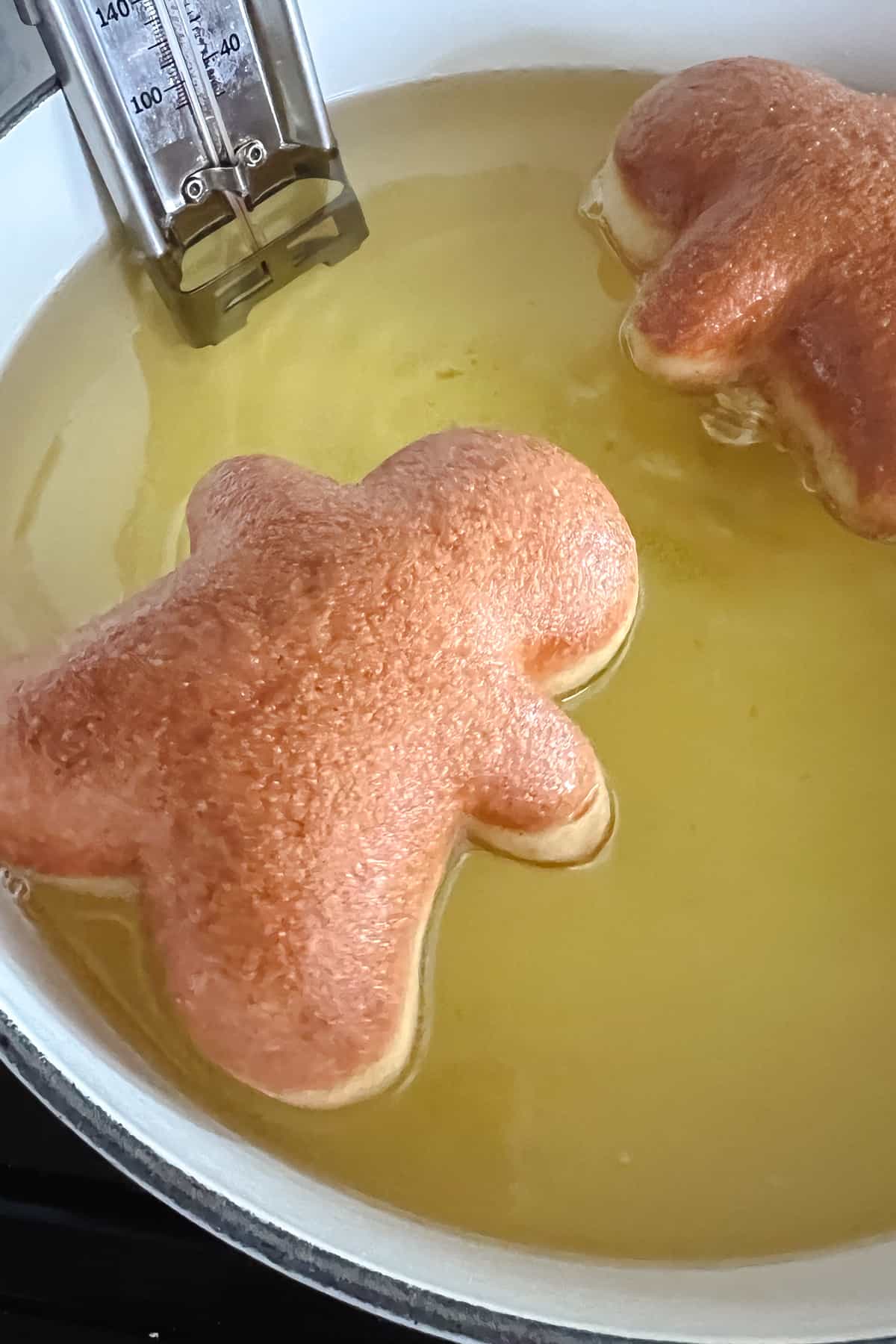 Gingerbread donuts are fried in a large dutch oven