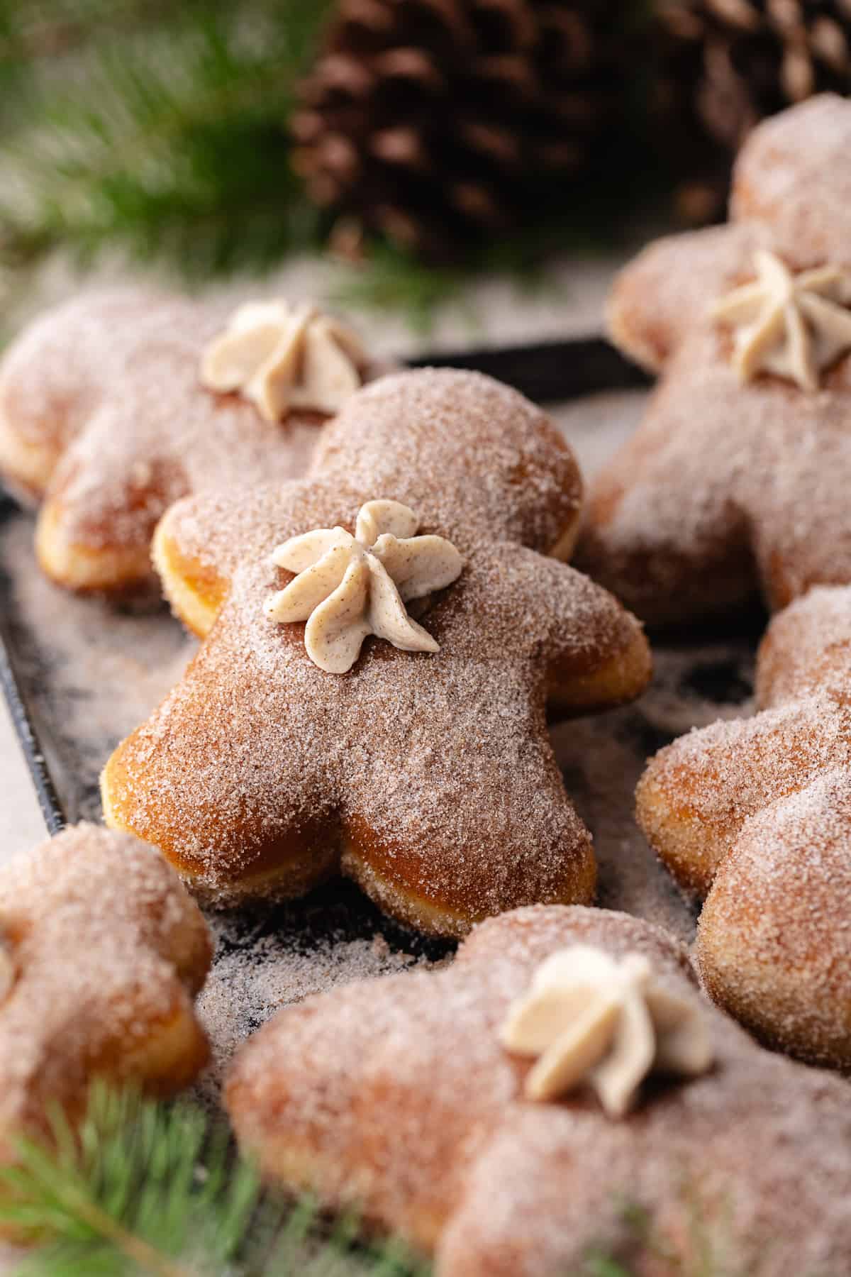 Gingerbread Cheesecake Donuts on a tray with cinnamon sugar