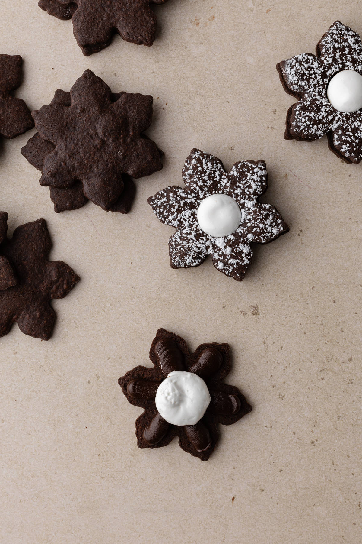 Filling bottom linzer cookie with chocolate ganache and marshmallow