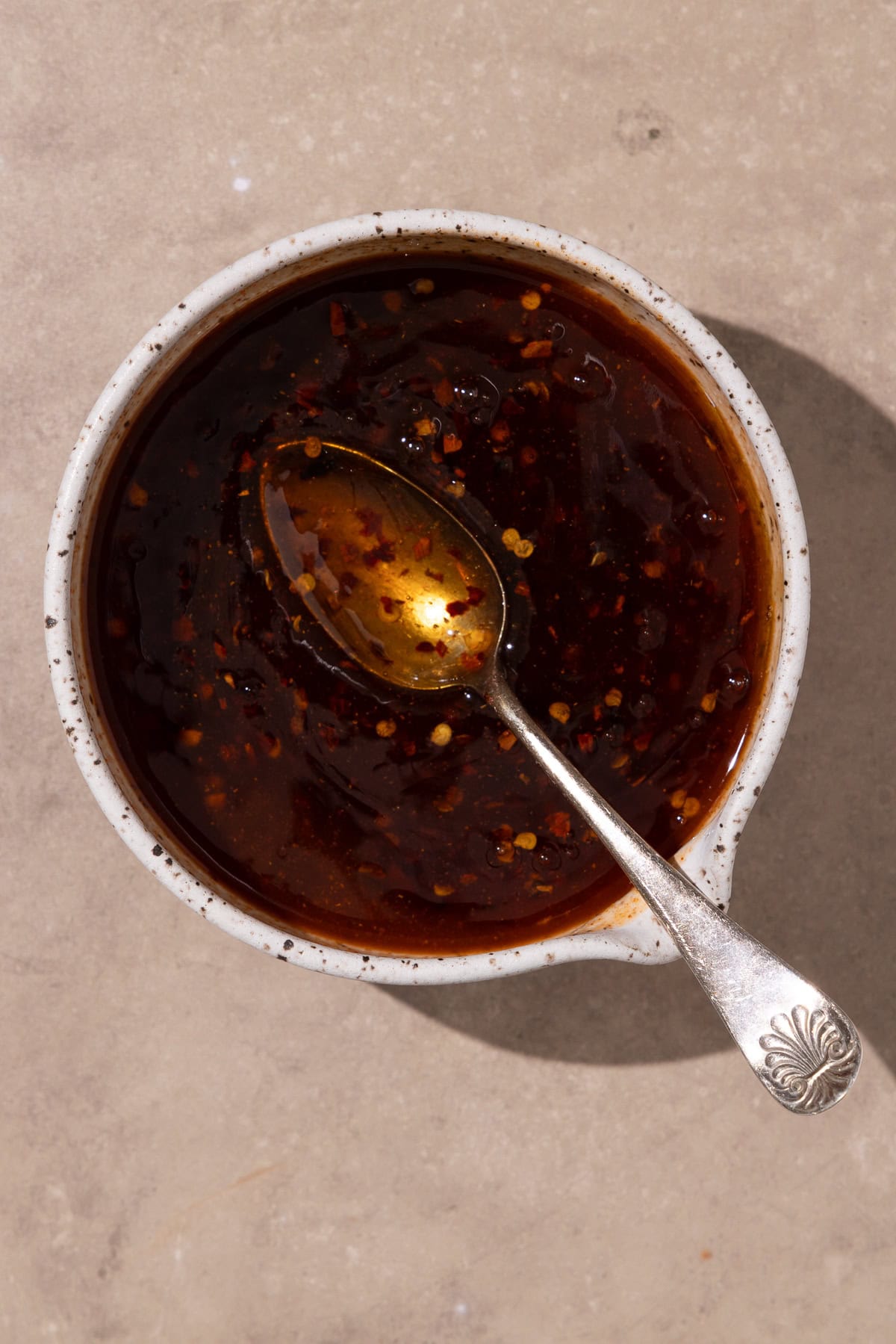 Hot honey ingredients mixed together in a small bowl with a spoon.