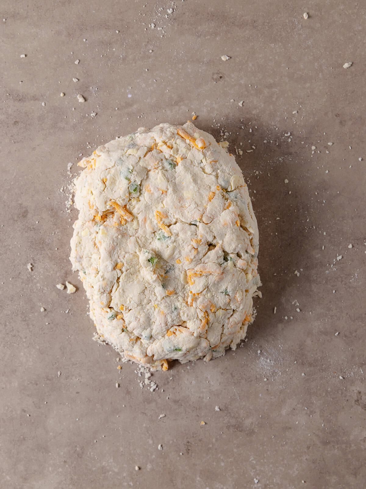 The dough is transferred to a work surface and is gathered together.