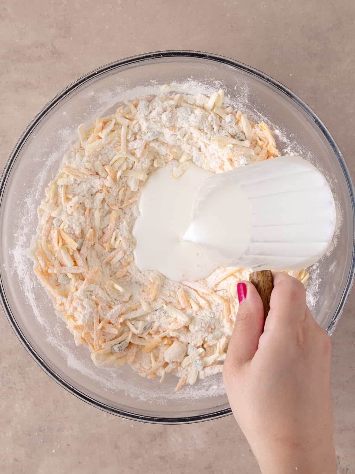 Buttermilk is poured into the bowl with the flour, cheese and jalapeno mixture.