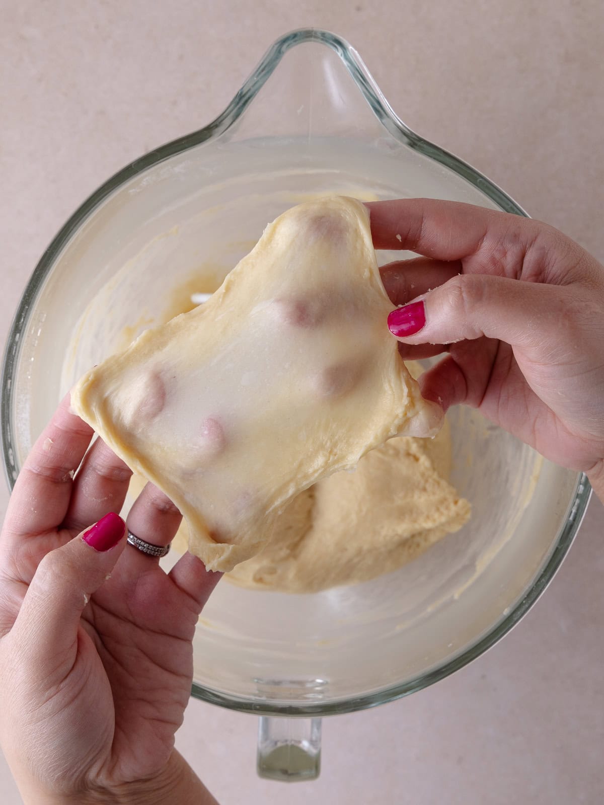 A small ball of dough has been stretched thin enough to allow light to pass through. This is known as a "window pane test."