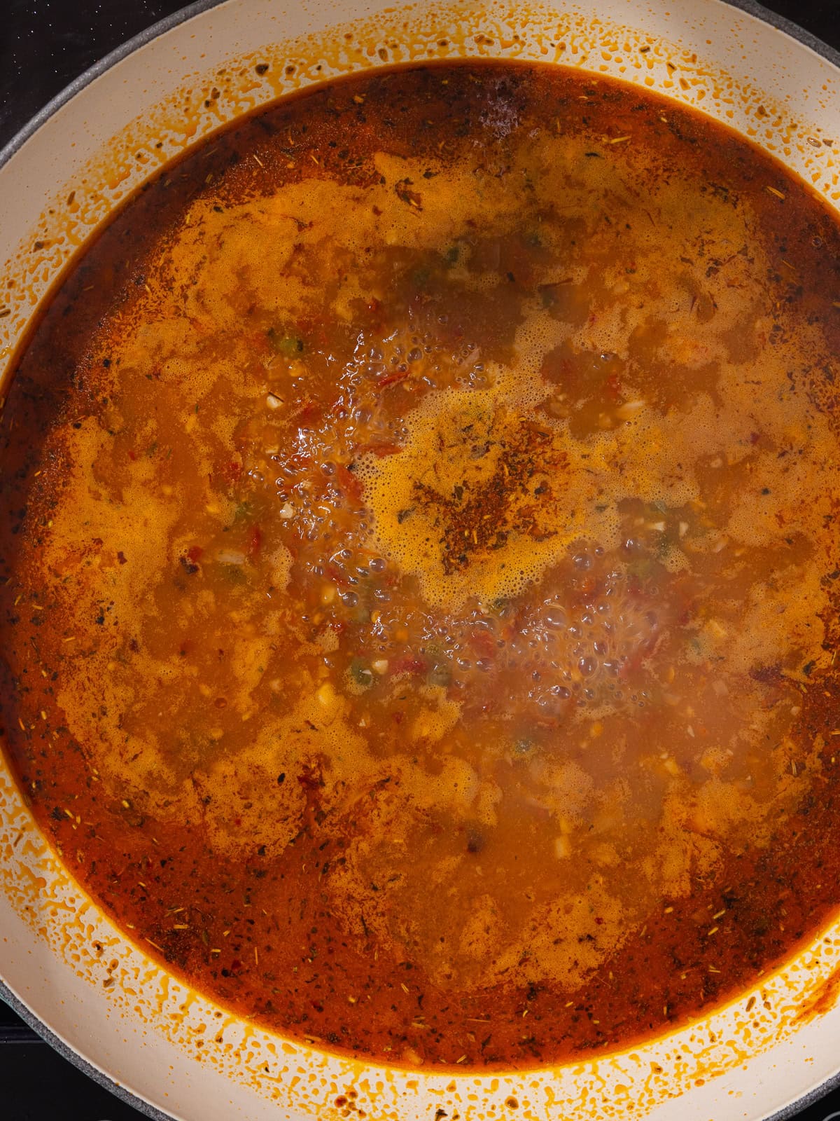 Chicken stock is added to the pan and us brought to a boil.