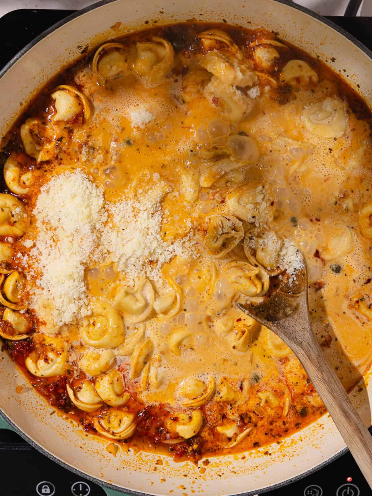 Heavy cream and grated parmesan cheese are added to the pot.