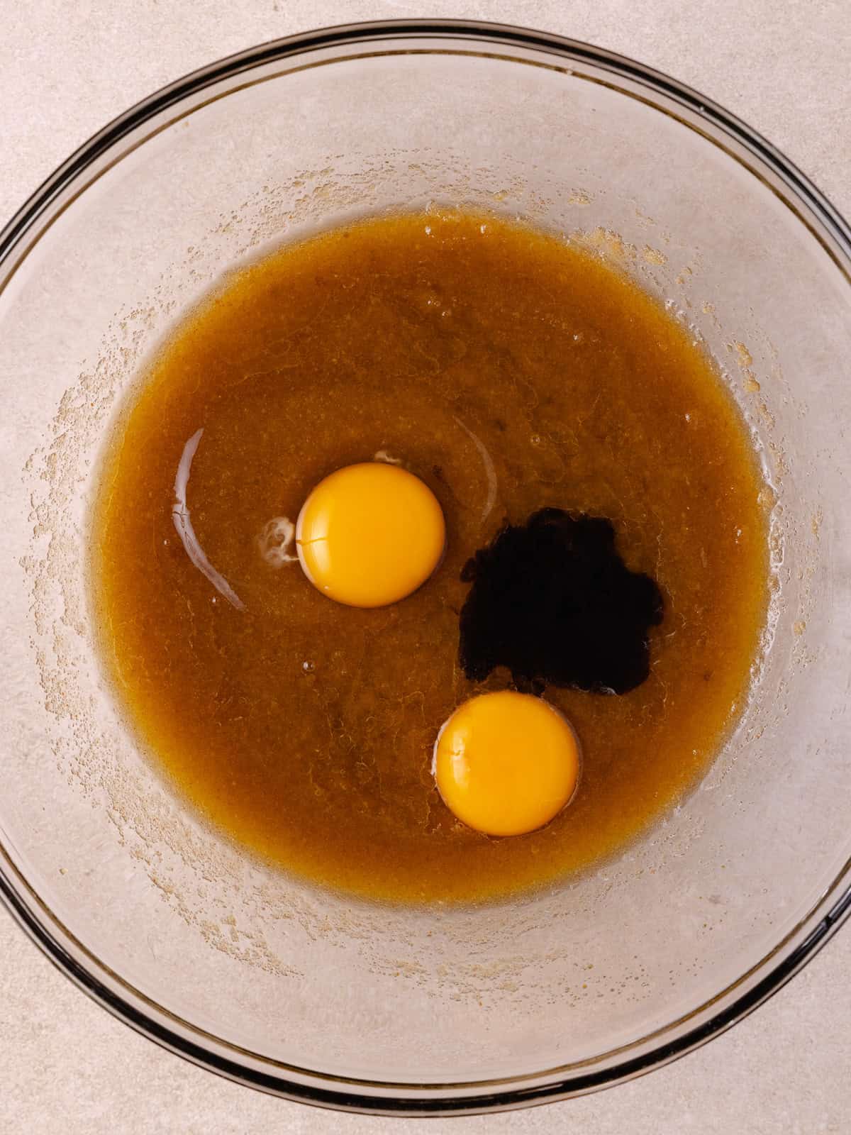 One whole egg, 1 yolk and vanilla paste are added to bowl of brown butter and sugars.