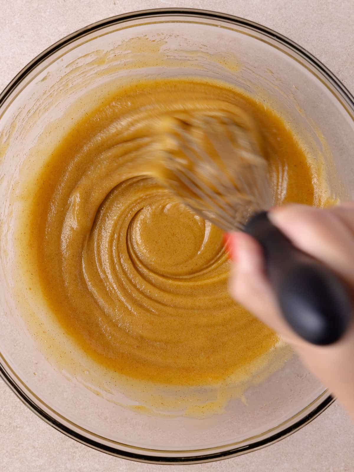 Whisking brown butter, brown sugar, white sugar, egg, yolk and vanilla are whisked together by hand.