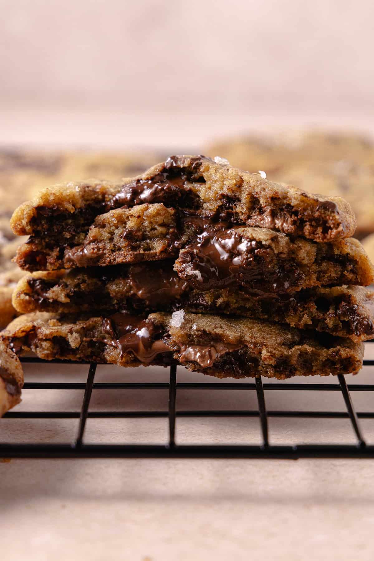 A stack of brown butter chocolate chip cookies on a cooling rack.