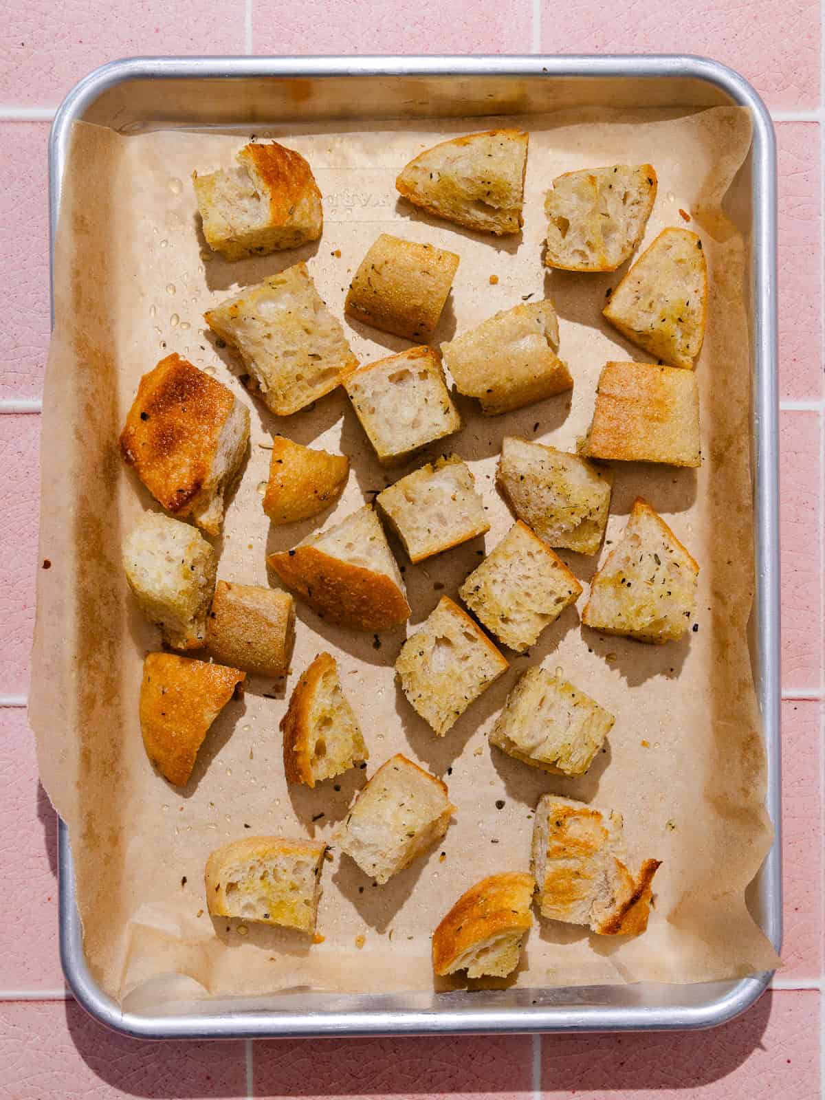 Cubed sourdough bread is baked until lightly toasted.