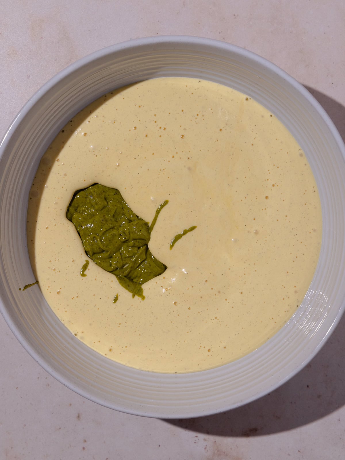 Pistachio paste is added to yolk mixture.