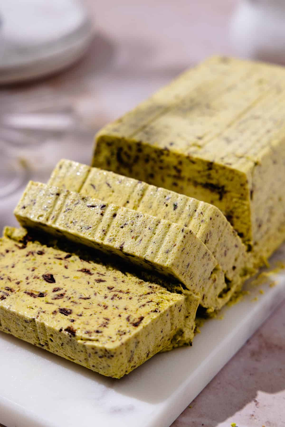 Sliced Pistachio Semifreddo on a marble cutting board.