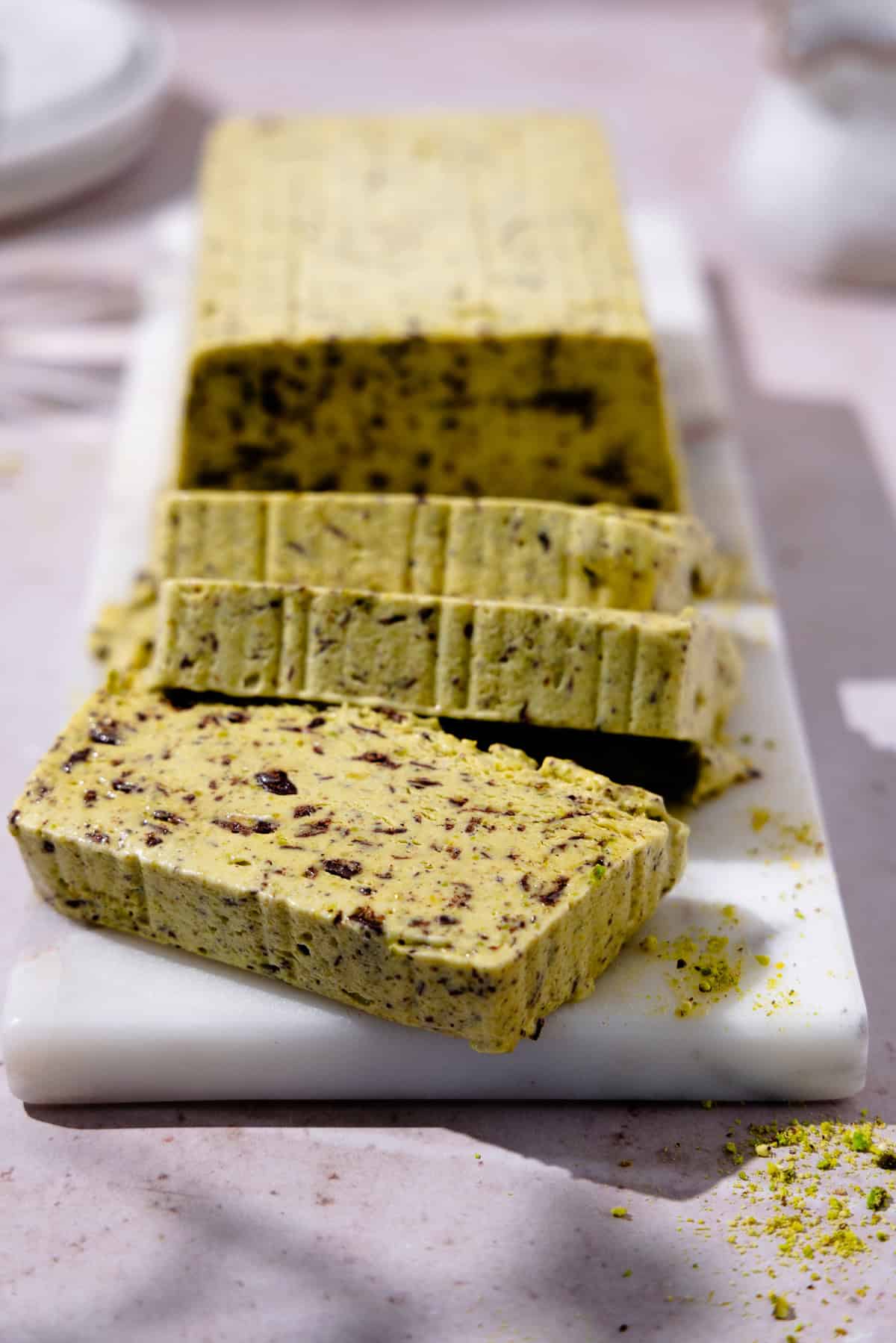 Sliced Pistachio Semifreddo on a marble cutting board.