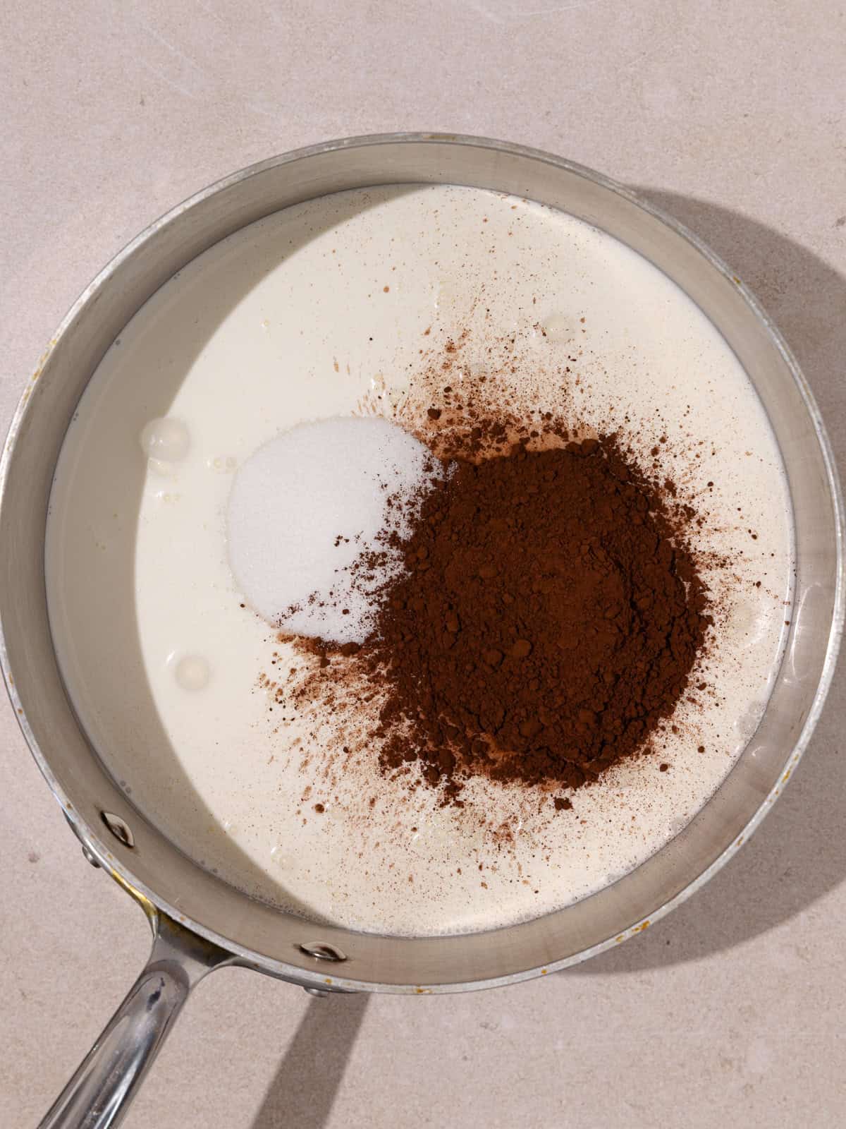 Heavy cream, whole milk, sugar and cocoa powder are added to a saucepan.