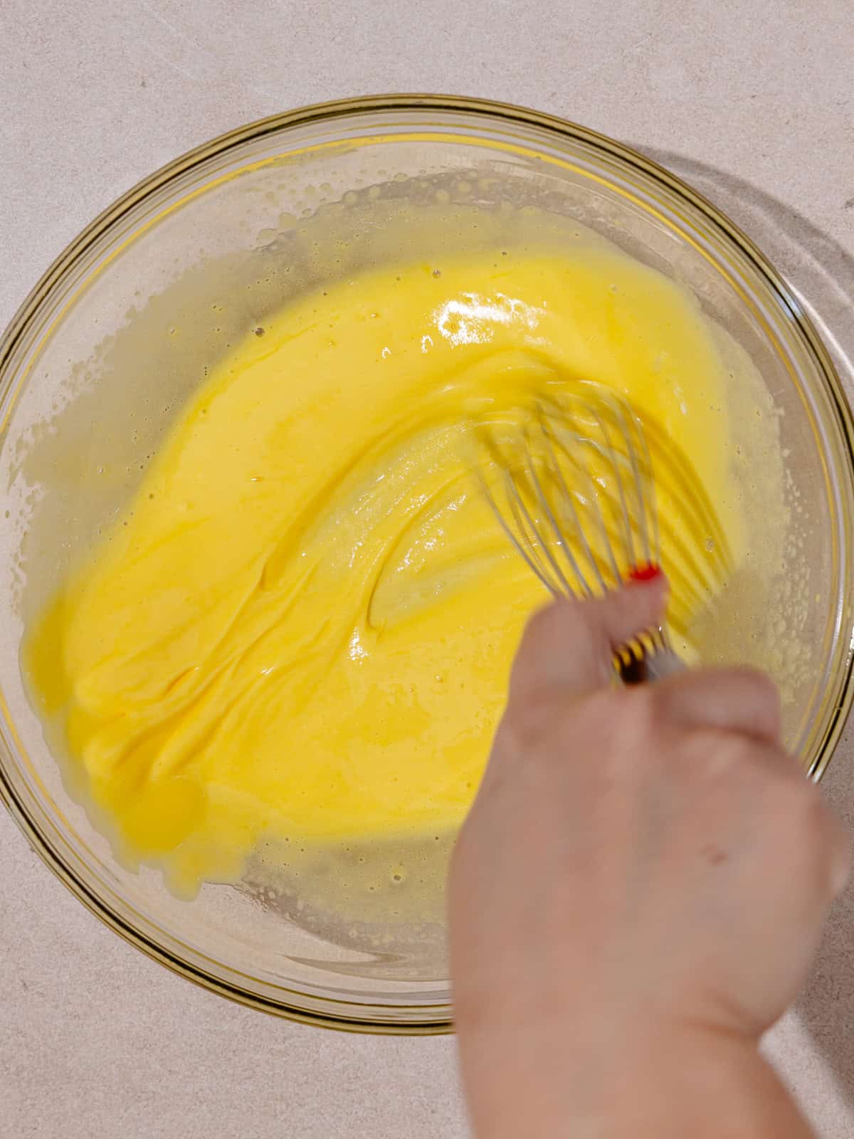 Yolks and sugar is whisked until pale in color and thick.