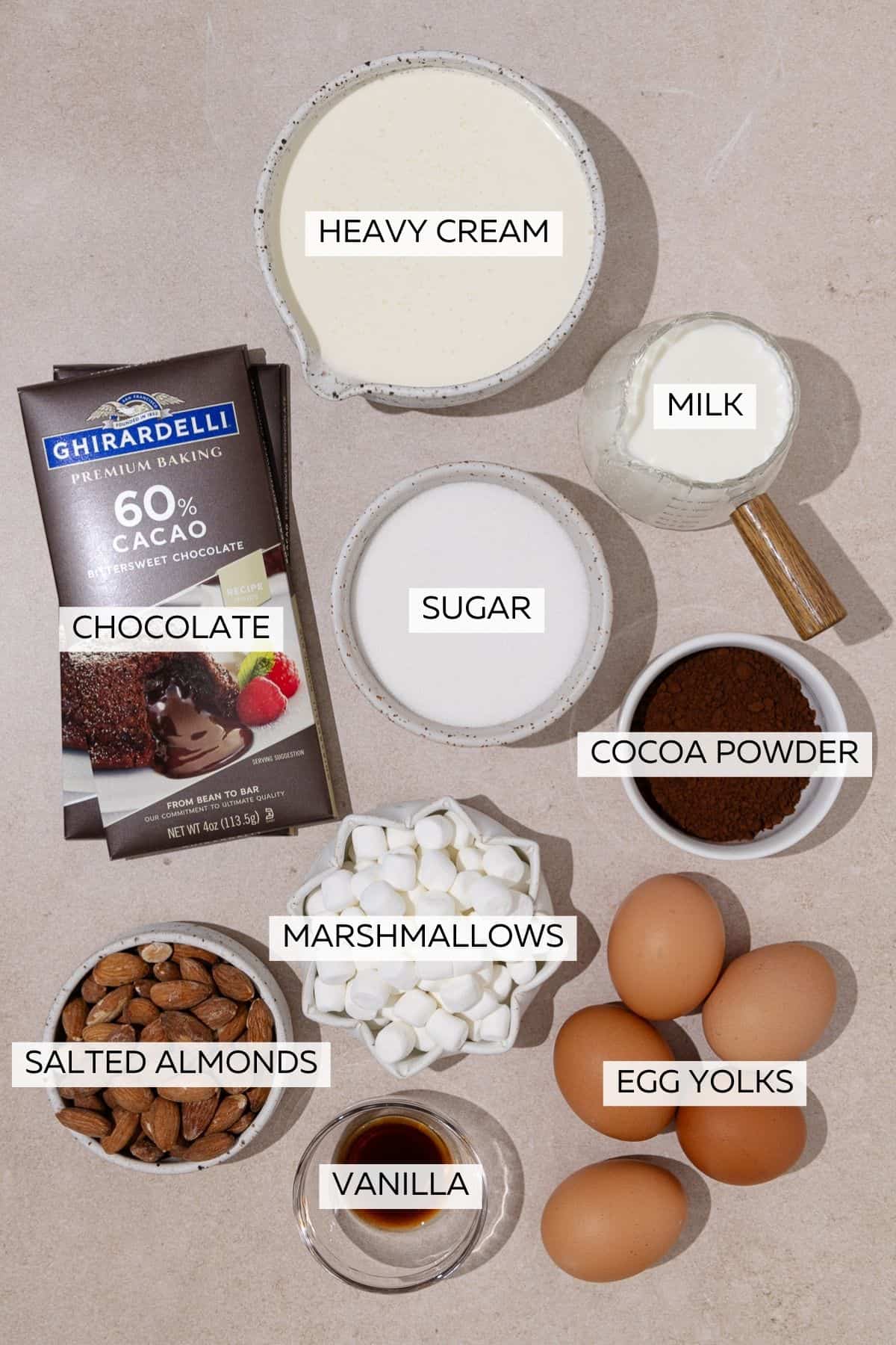 Rocky road ice cream ingredients, which include, heavy cream, milk, egg yolks, sugar, chocolate bars, mini marshmallows and salted roasted almonds.