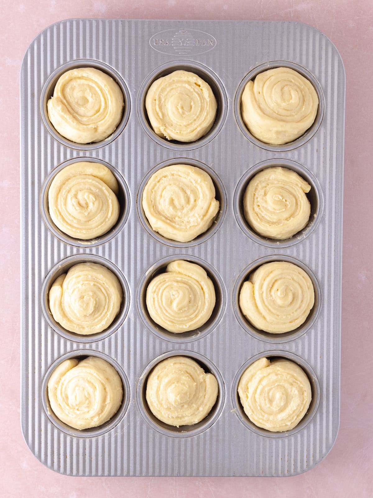 The rolls are placed in a buttered muffin pan.