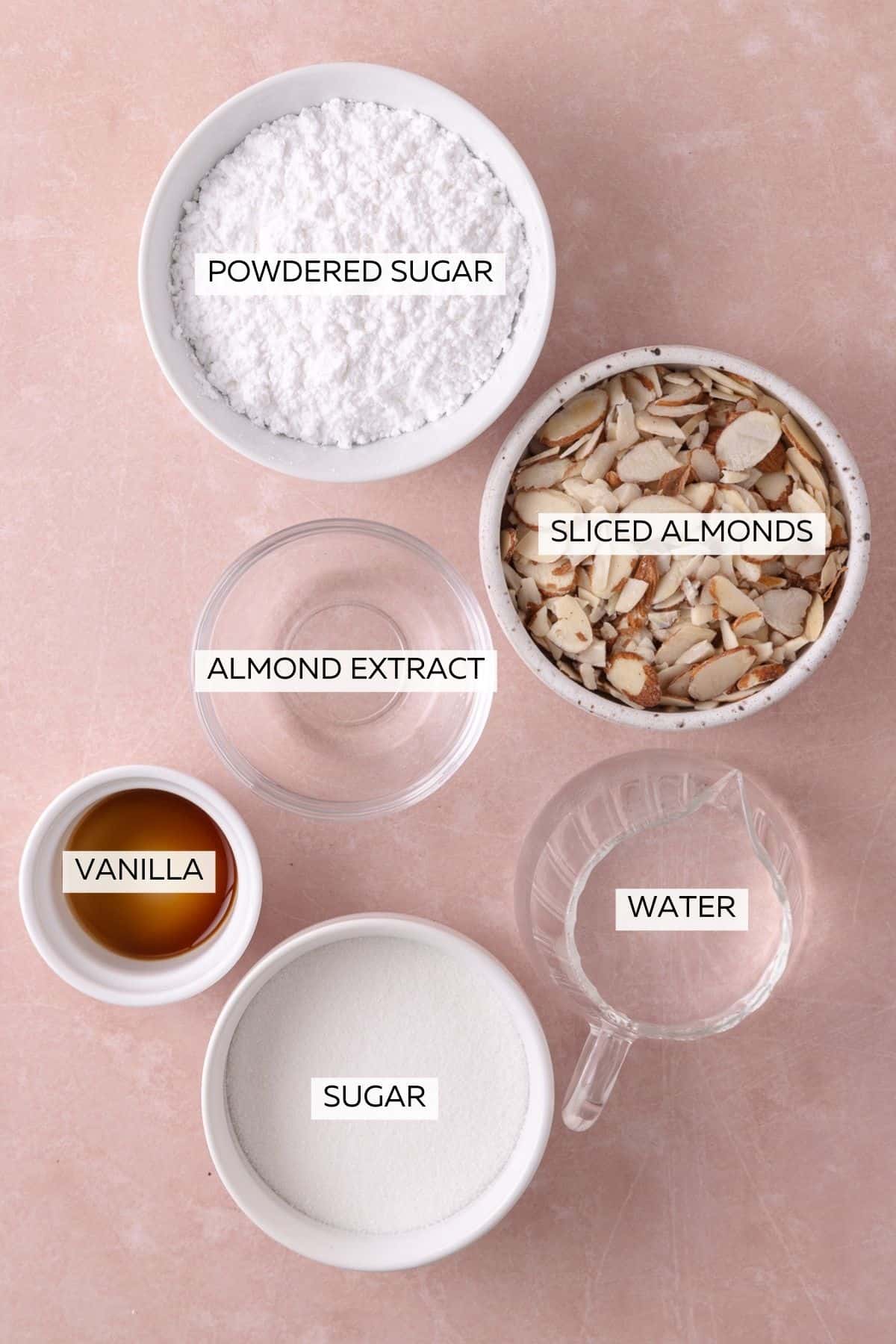 Ingredients for the almond syrup and toppings, which include, sugar, almond extract, vanilla extract, water, sliced almonds and powdered sugar.