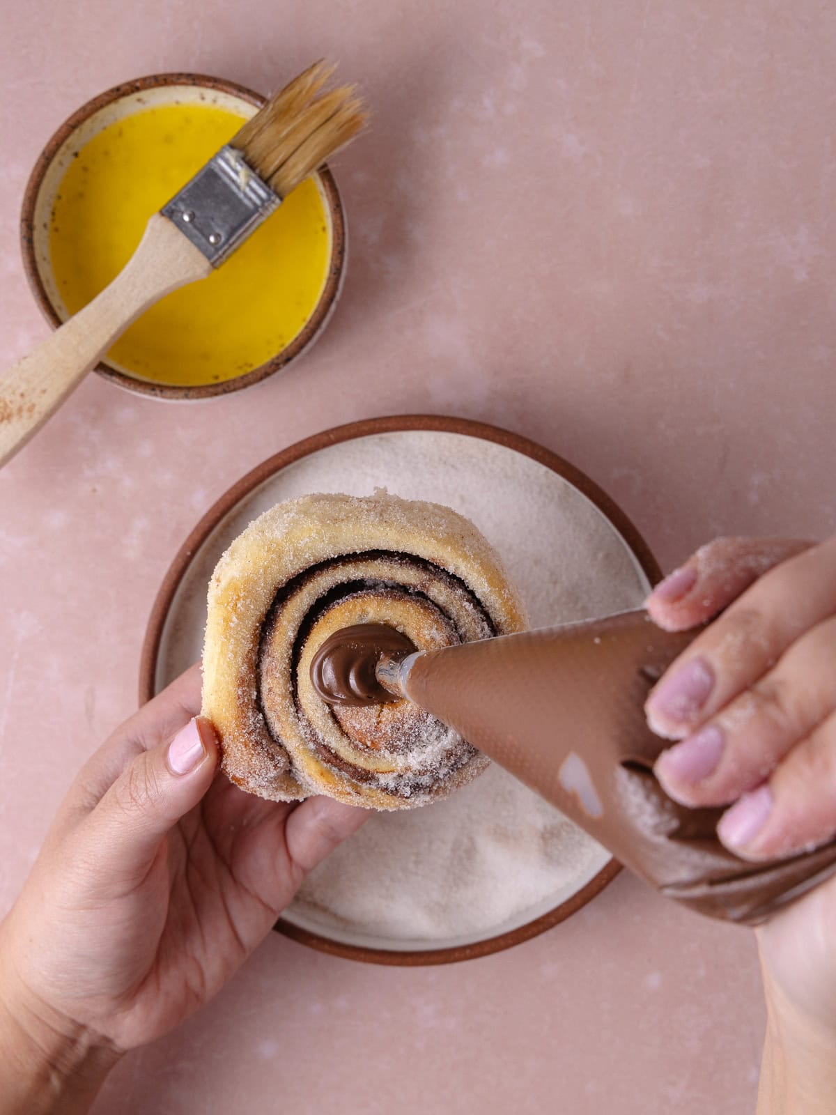 Nutella in a piping bag fills the center of the Nutella roll.