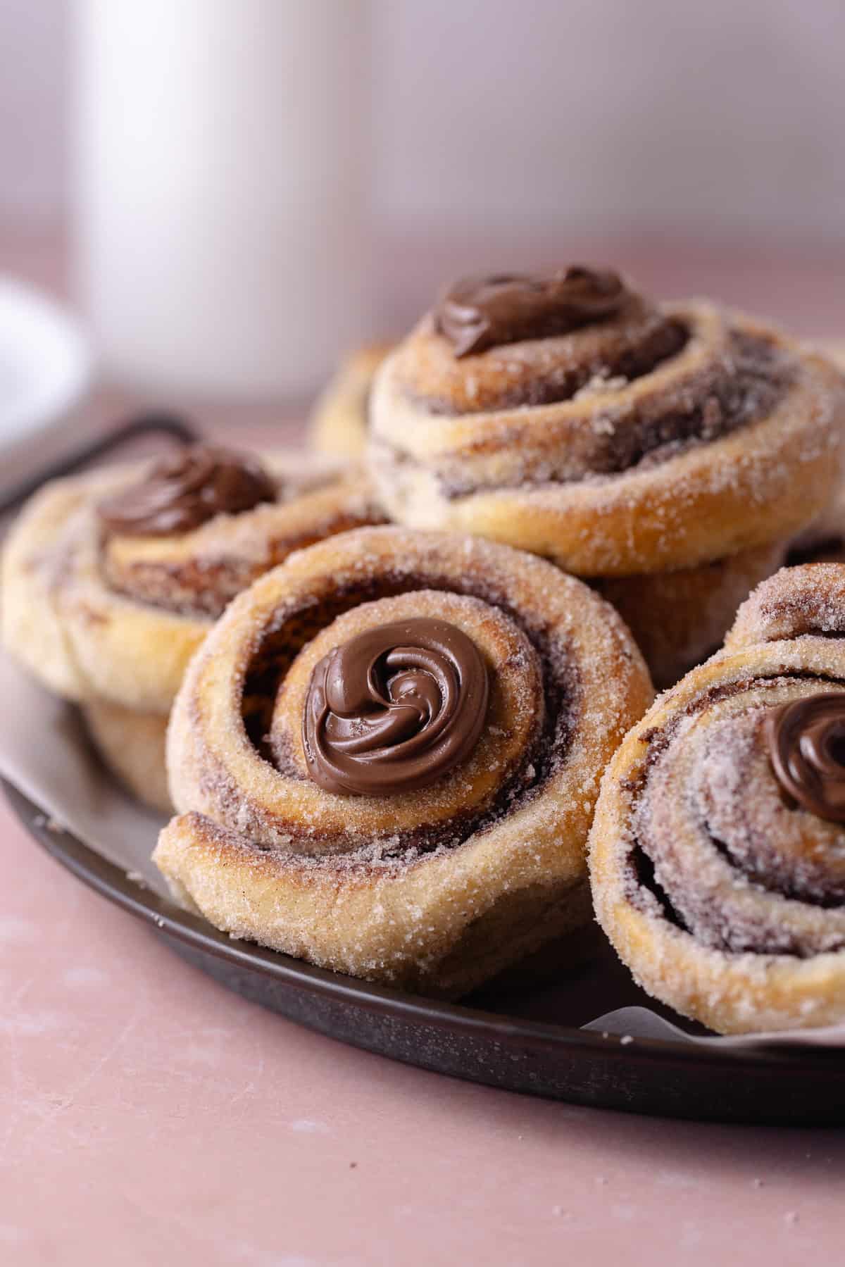 A close up of a pile of Nutella Cinnamon Rolls on a serving platter.