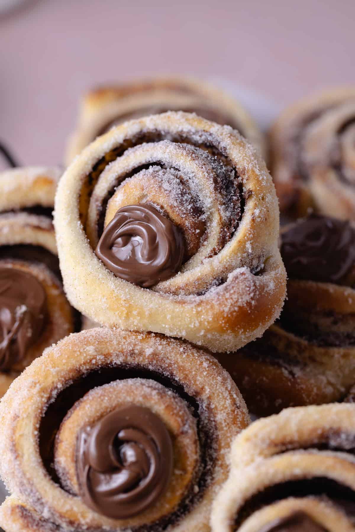 A close up of a pile of Nutella Cinnamon Rolls on a serving platter.