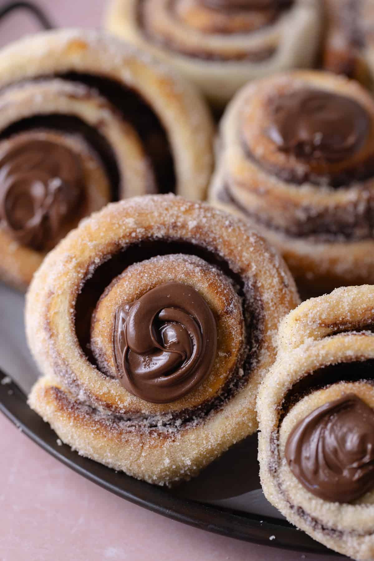 A close up of a pile of Nutella Cinnamon Rolls on a serving platter.