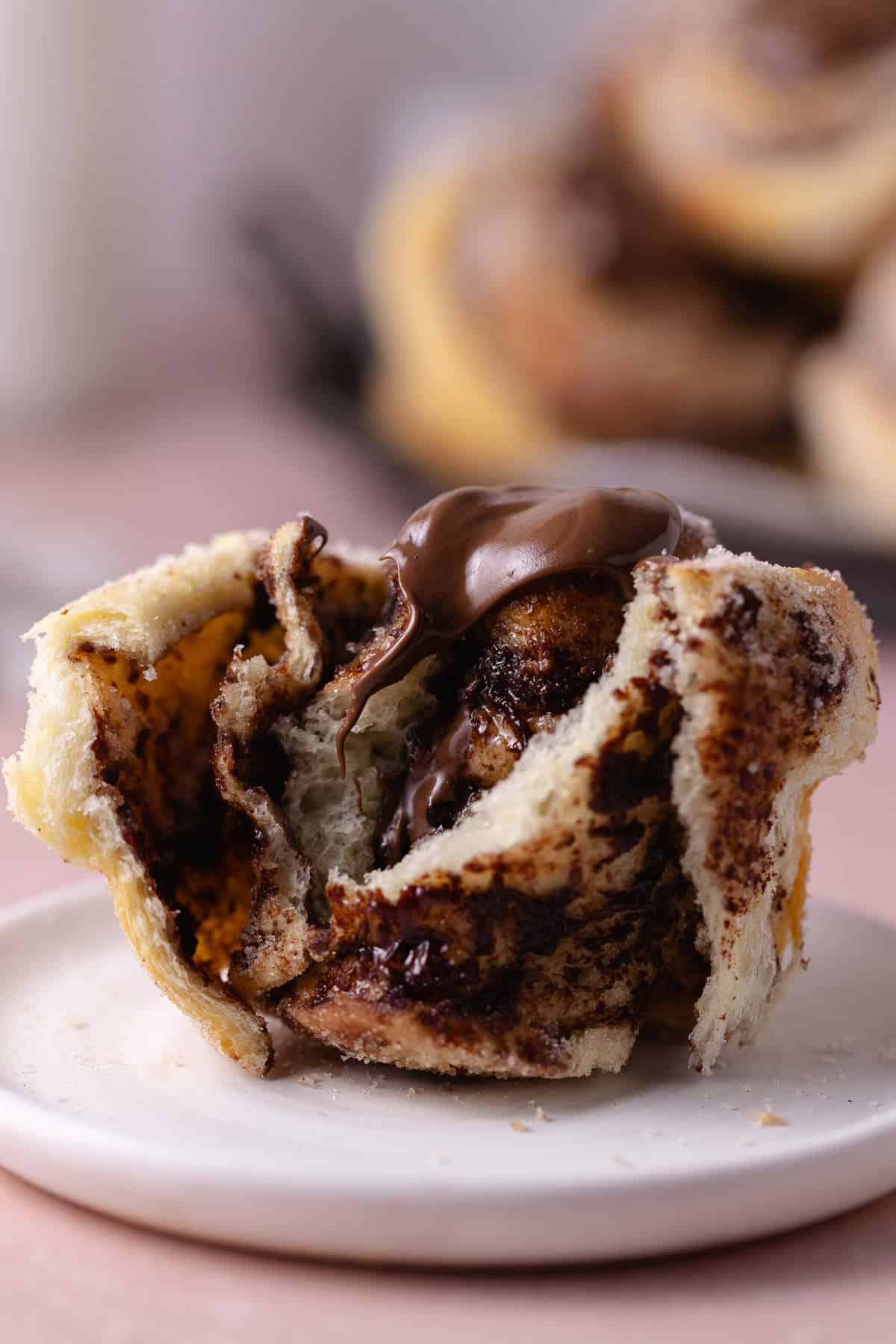 A close up of the inside of a Nutella Cinnamon Roll sitting on a small plate.