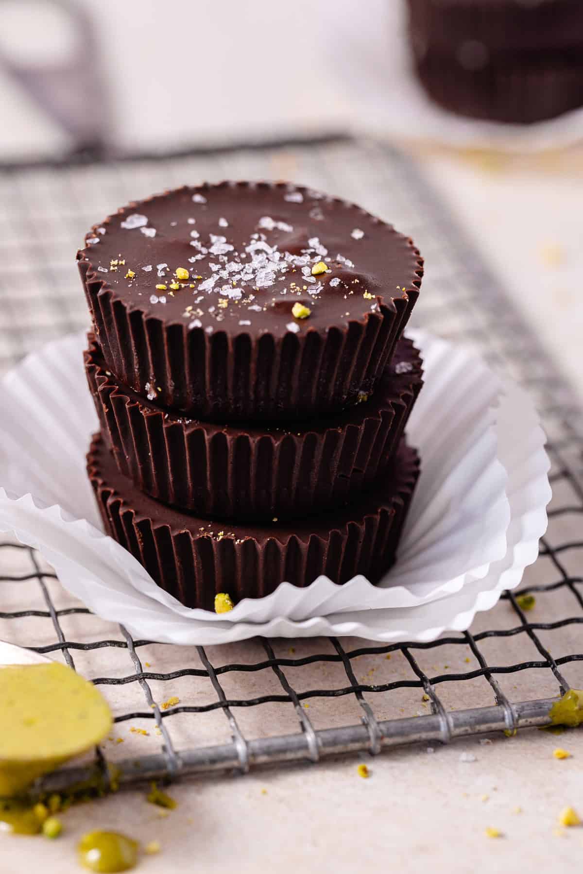 A stack of pistachio butter cups with flaky sea salt.