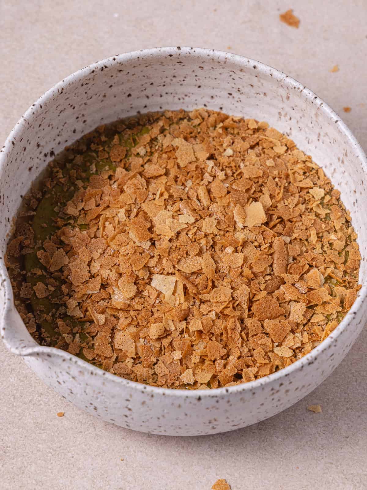 Pistachio butter, feuilletine flakes and honey are in a medium bowl.