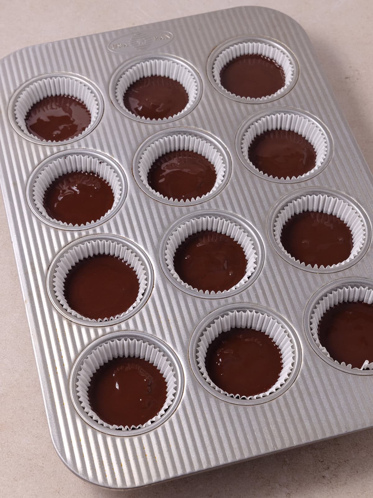 Pistachio butter chocolate cups topped with the top layer of chocolate.