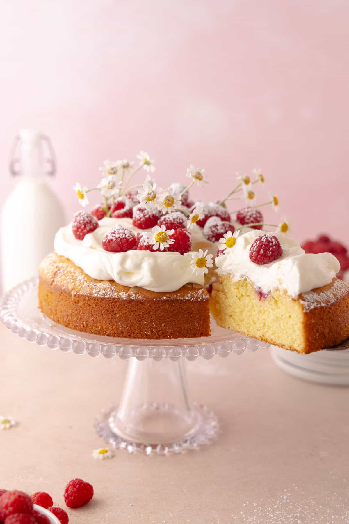 A slice of raspberry olive cake is being removed with a cake server.