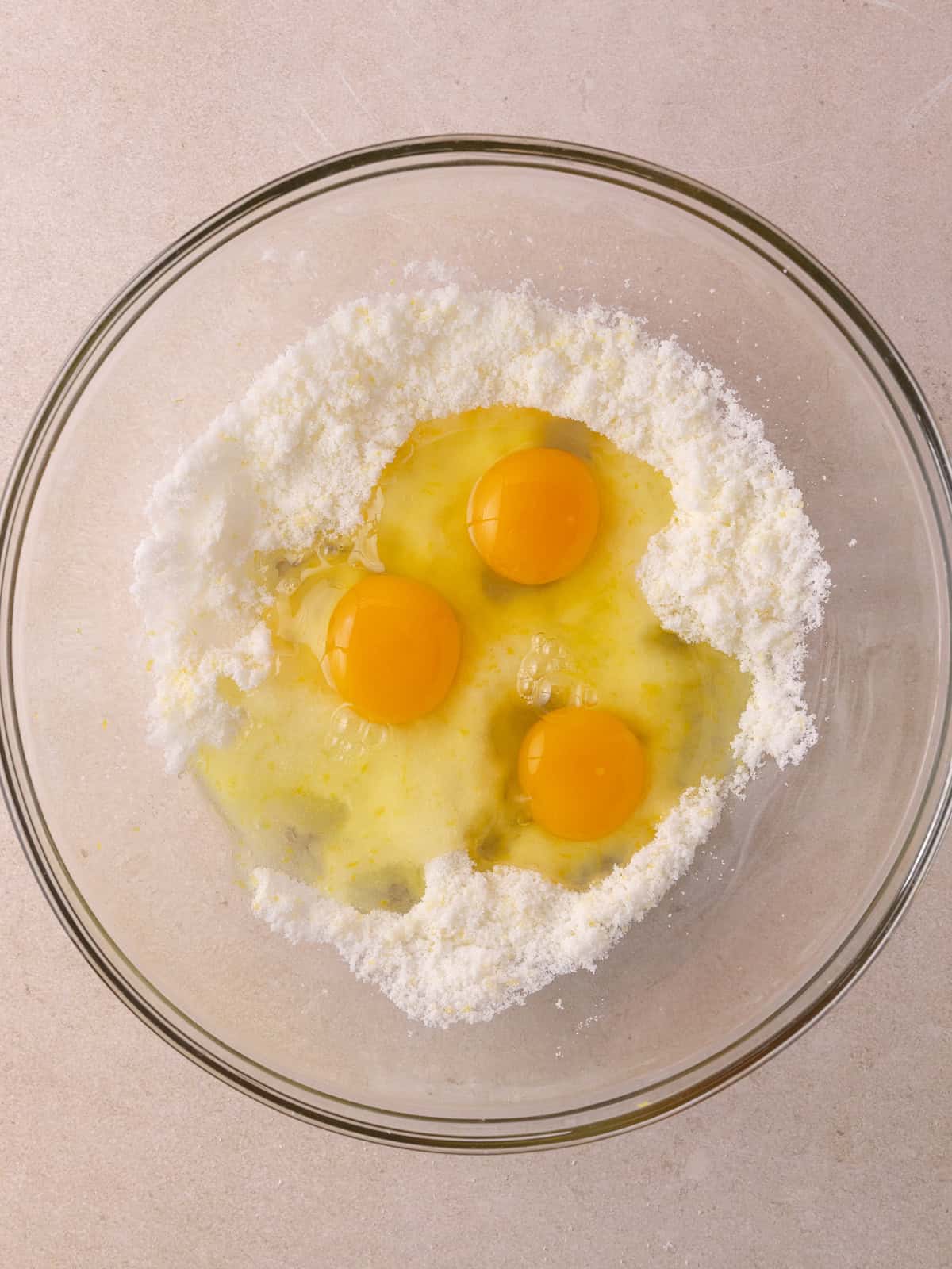 Three large whole eggs are added to the lemon sugar mixture.