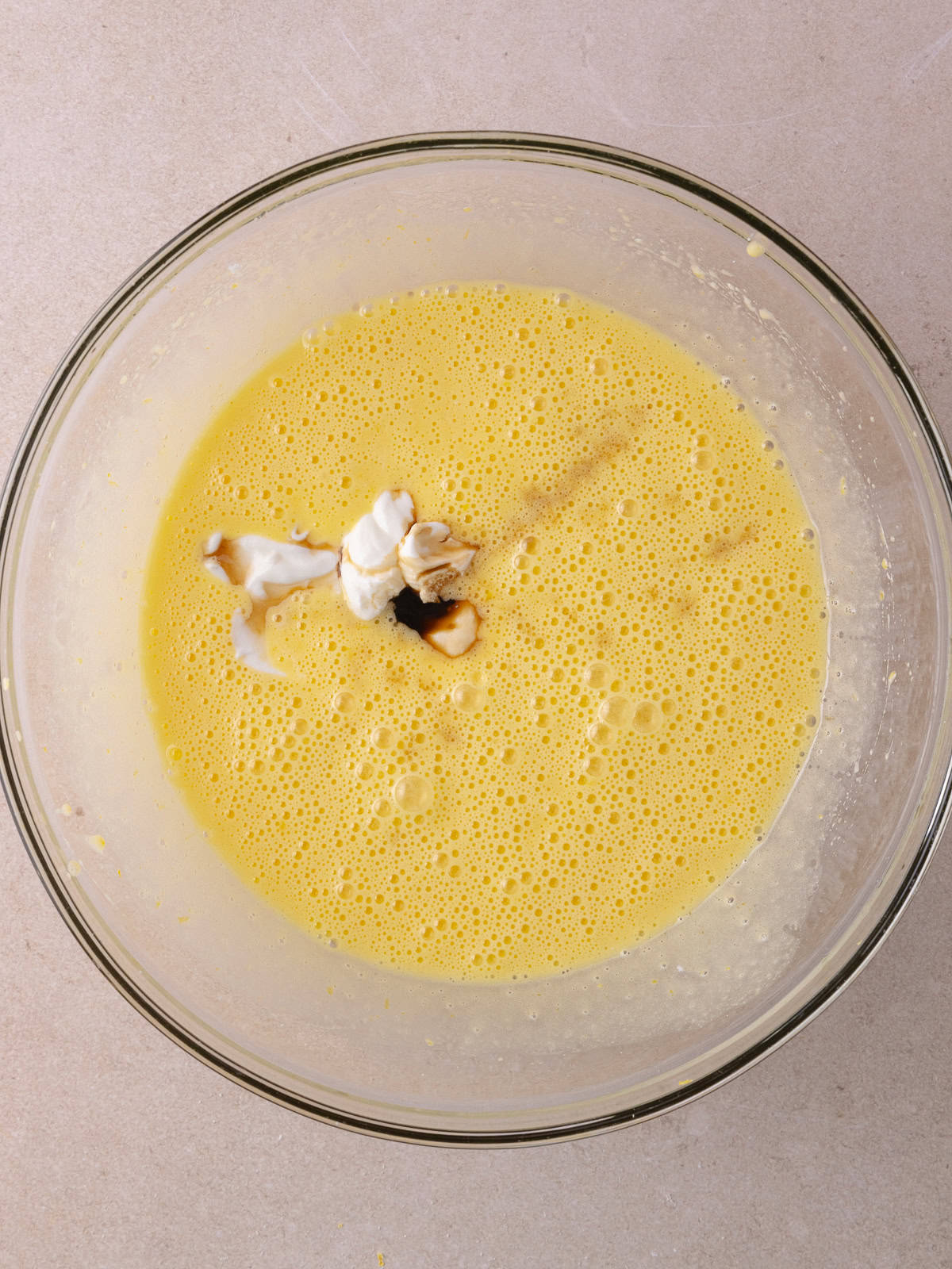 Greek yogurt, vanilla extract and almond extract are added to the egg, sugar, olive oil mixture.