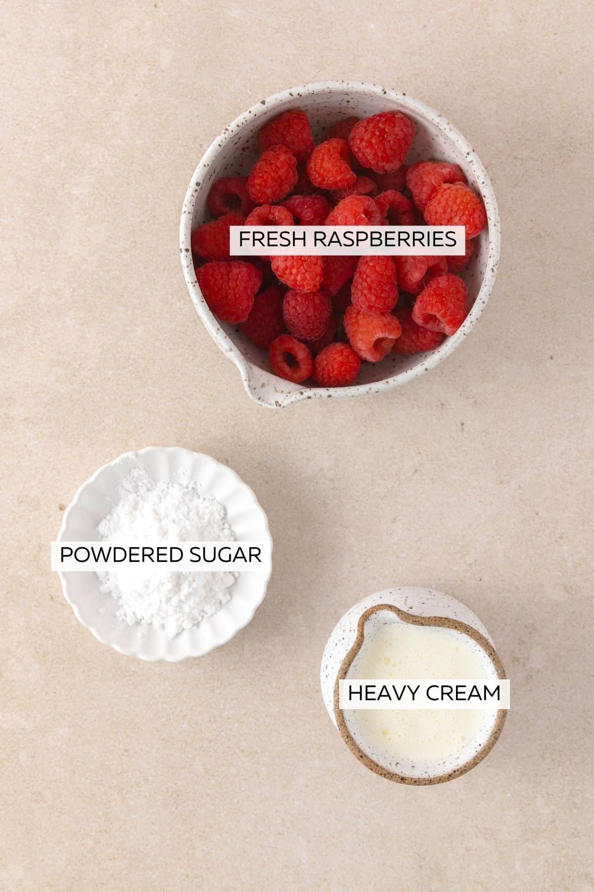 Topping ingredients, which include raspberries, powdered sugar and heavy cream.