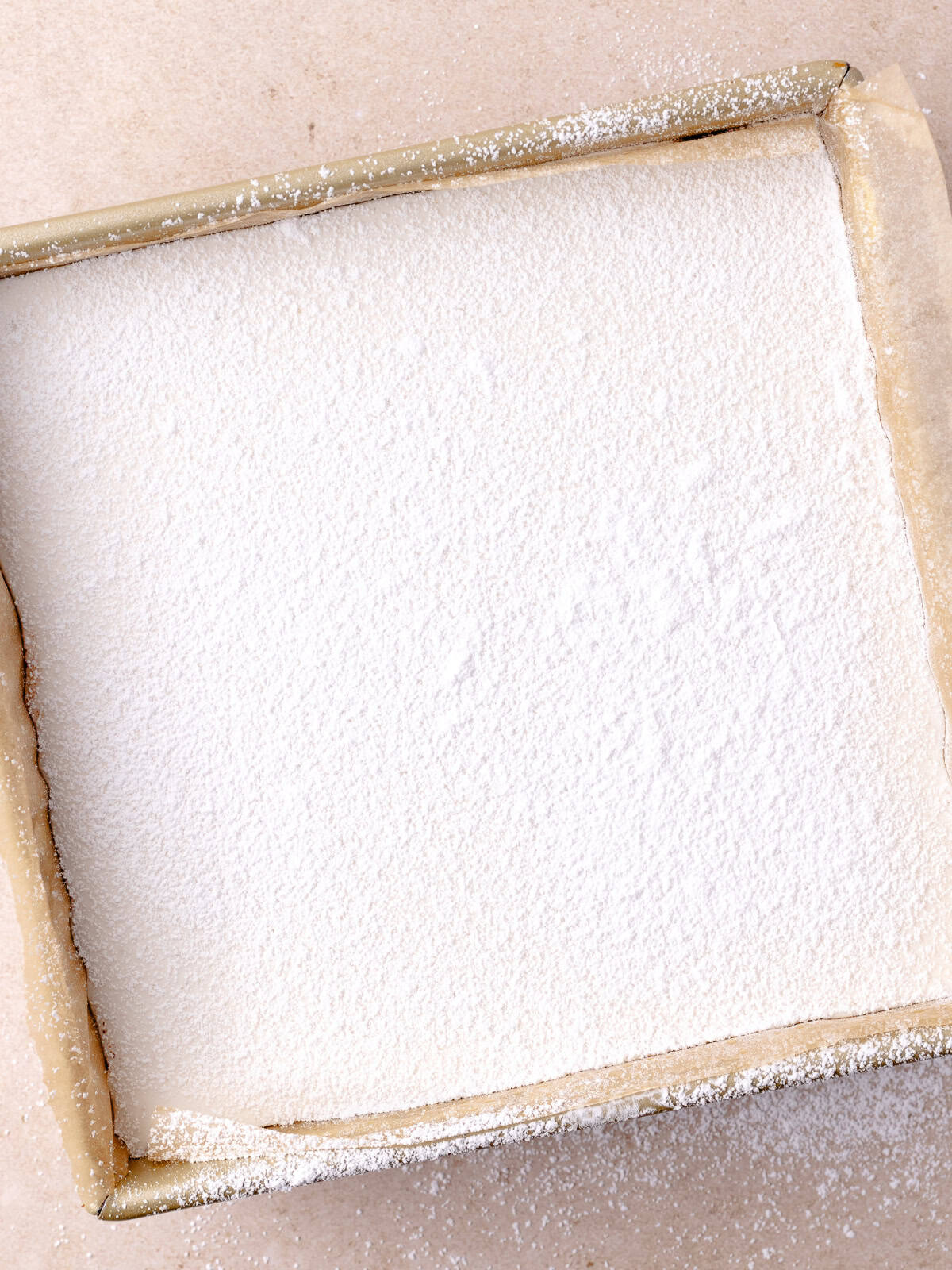 A layer of powdered sugar is added on top of the marshmallow layer.