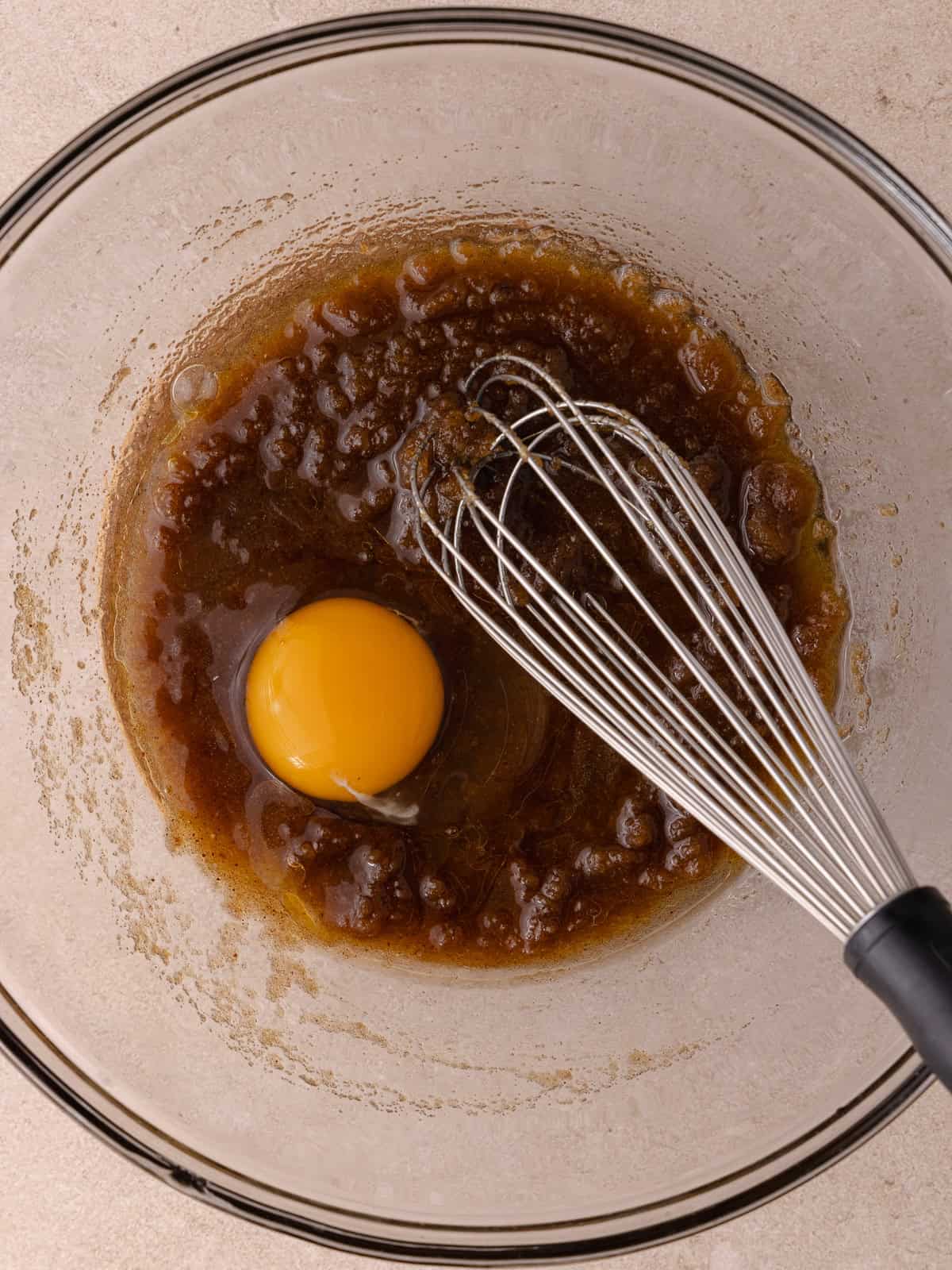 An egg is added to the butter and brown sugar mixture.