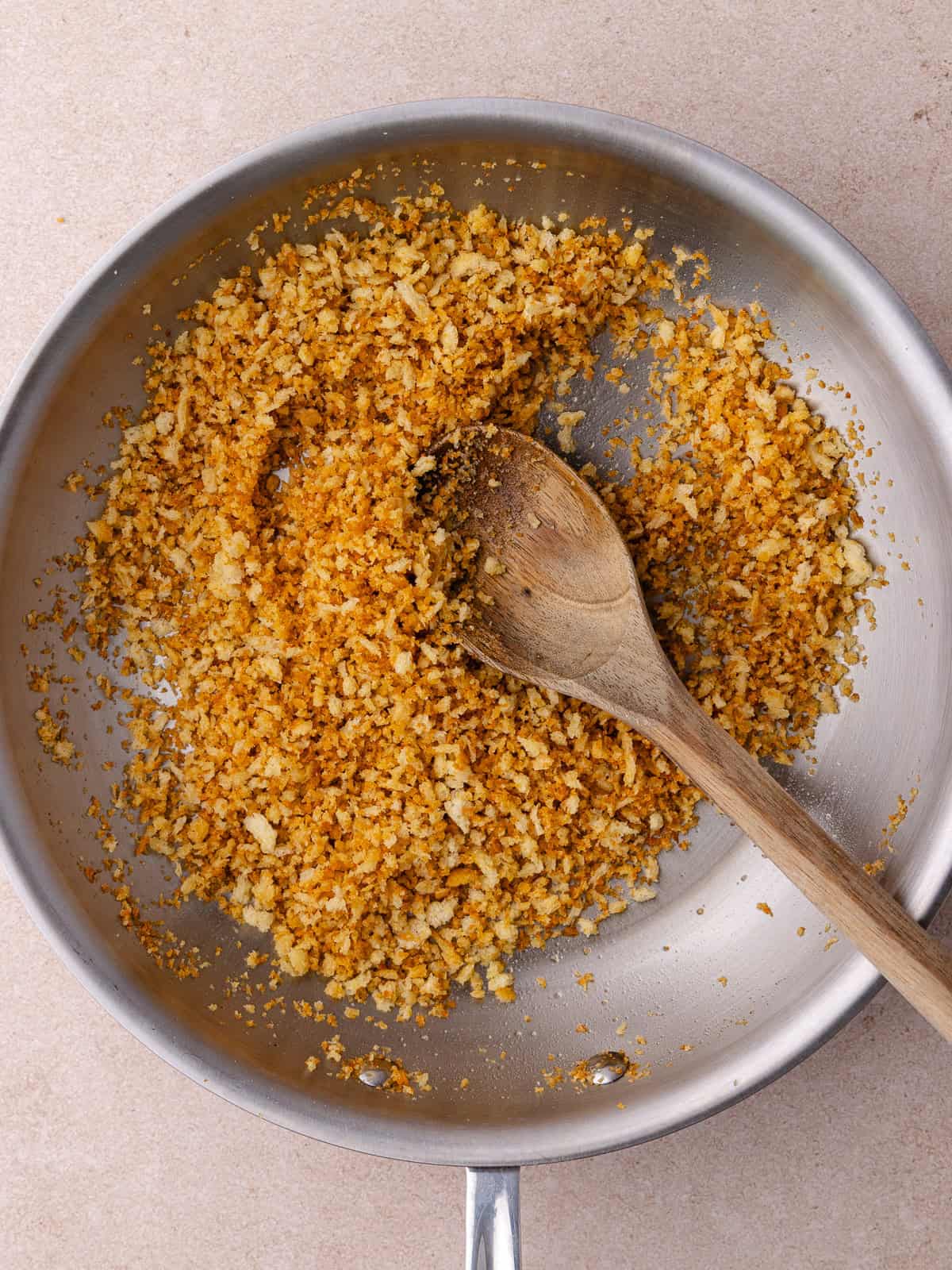 Panko crumbs are toasted in a pan until golden brown.