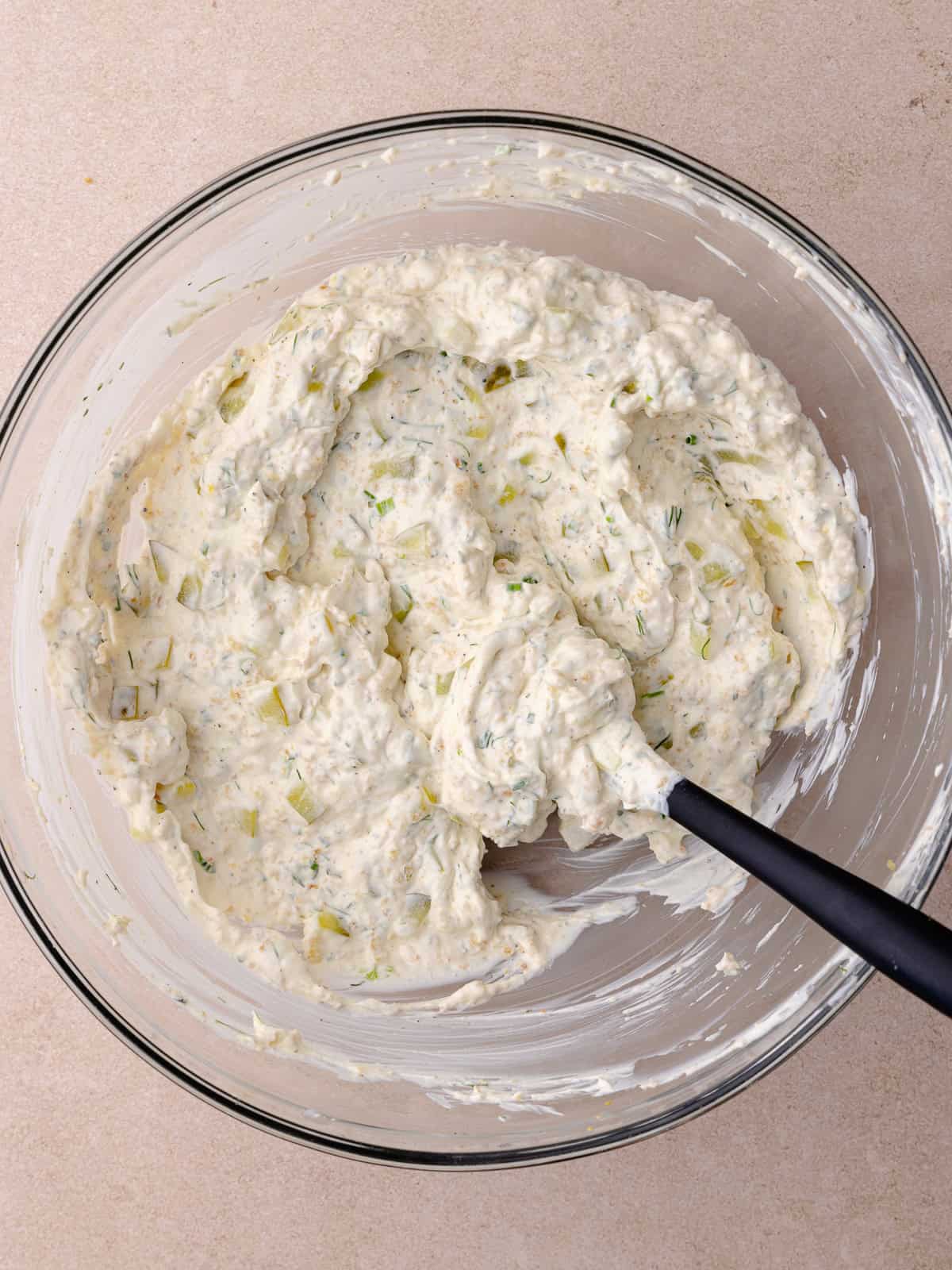 Fried pickle dip ingredients are combined in a mixing bowl.