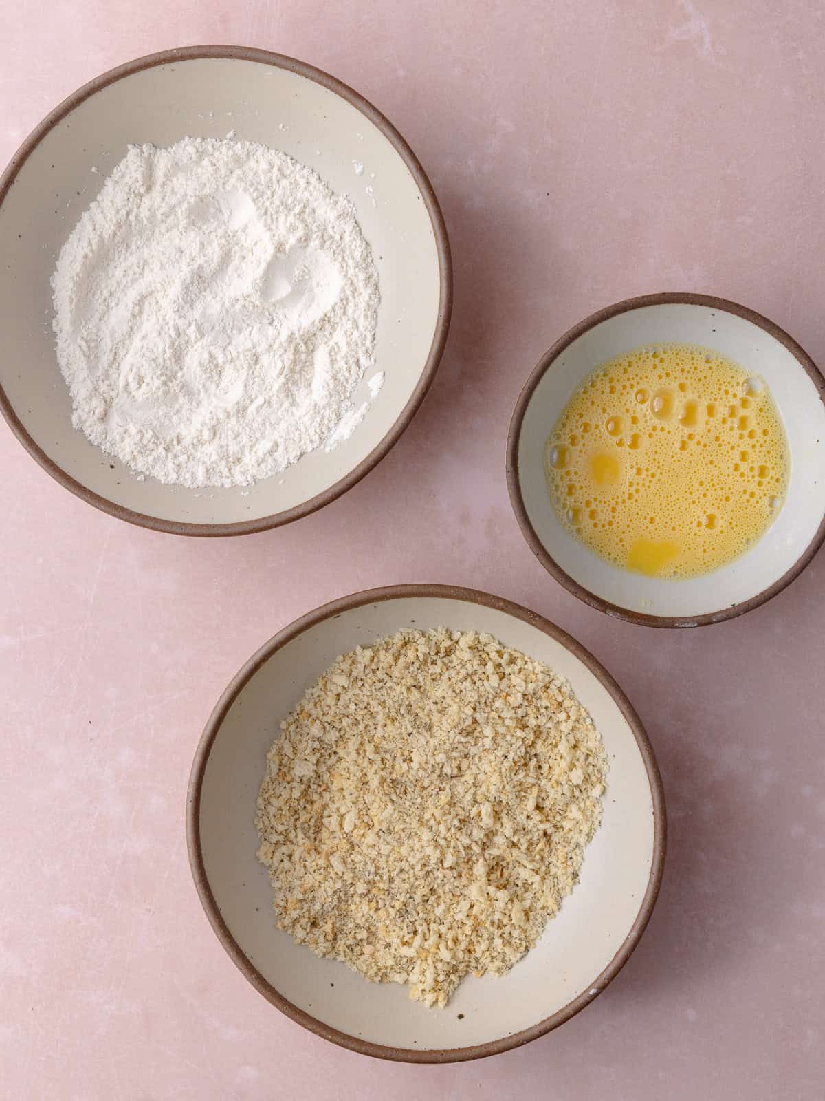 A bowl with flour, a bowl with seasoned panko and a bowl of egg wash is ready.