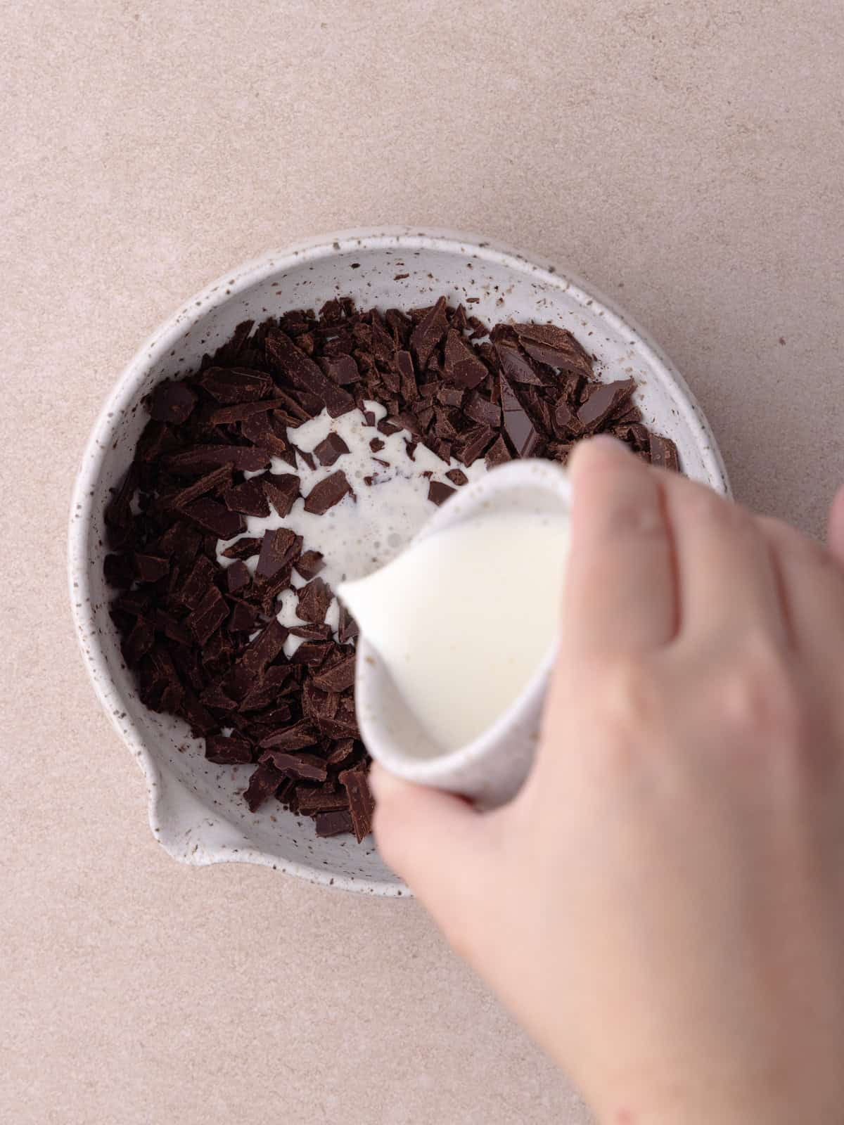 Hot cream is poured over finely chopped chocolate.