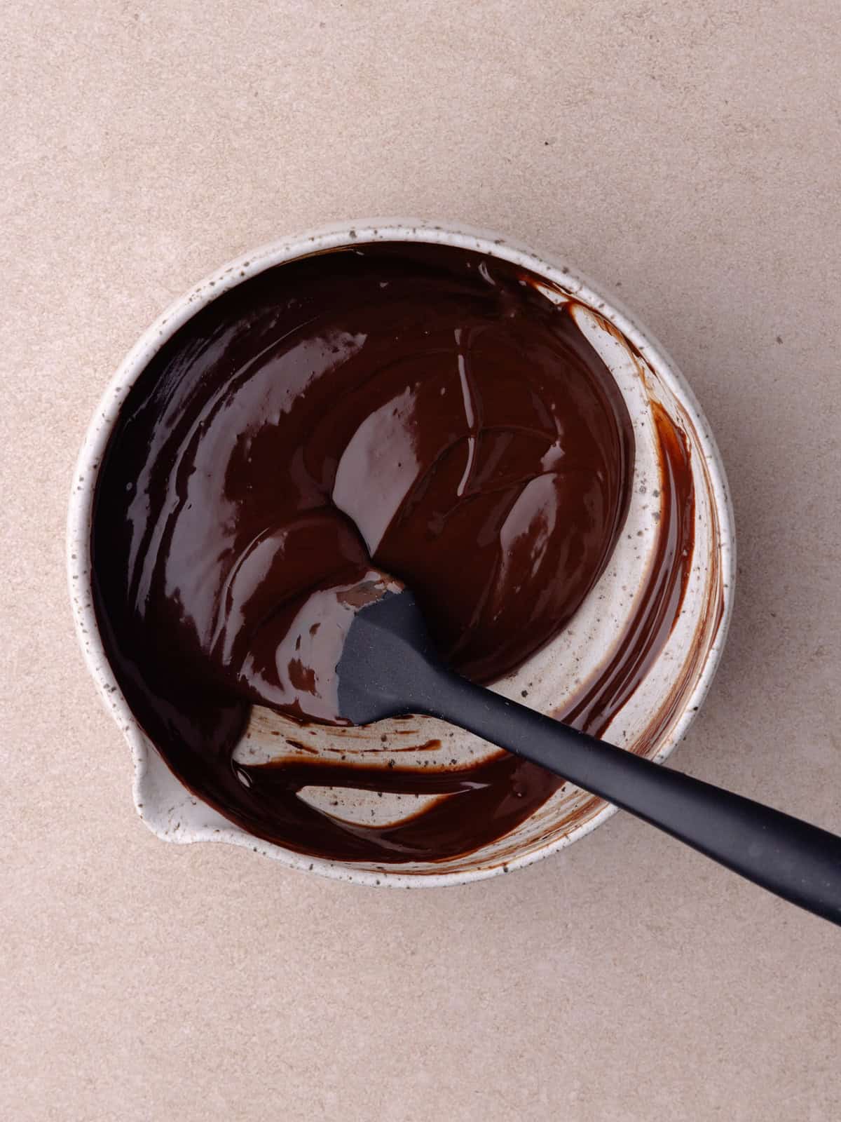 Chocolate ganache is stirred together.