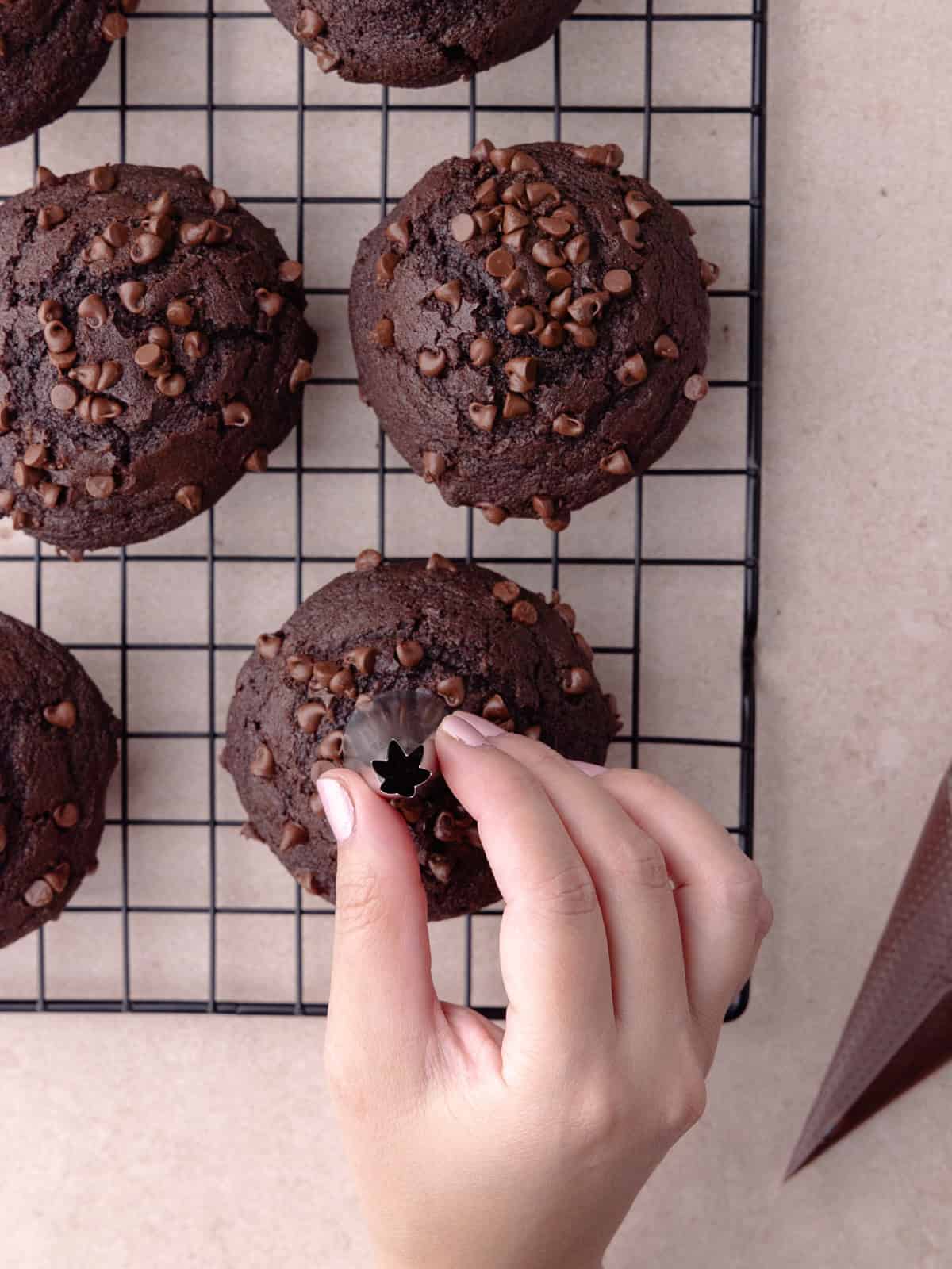 A piping tip carves out a hole in the center of each muffin.